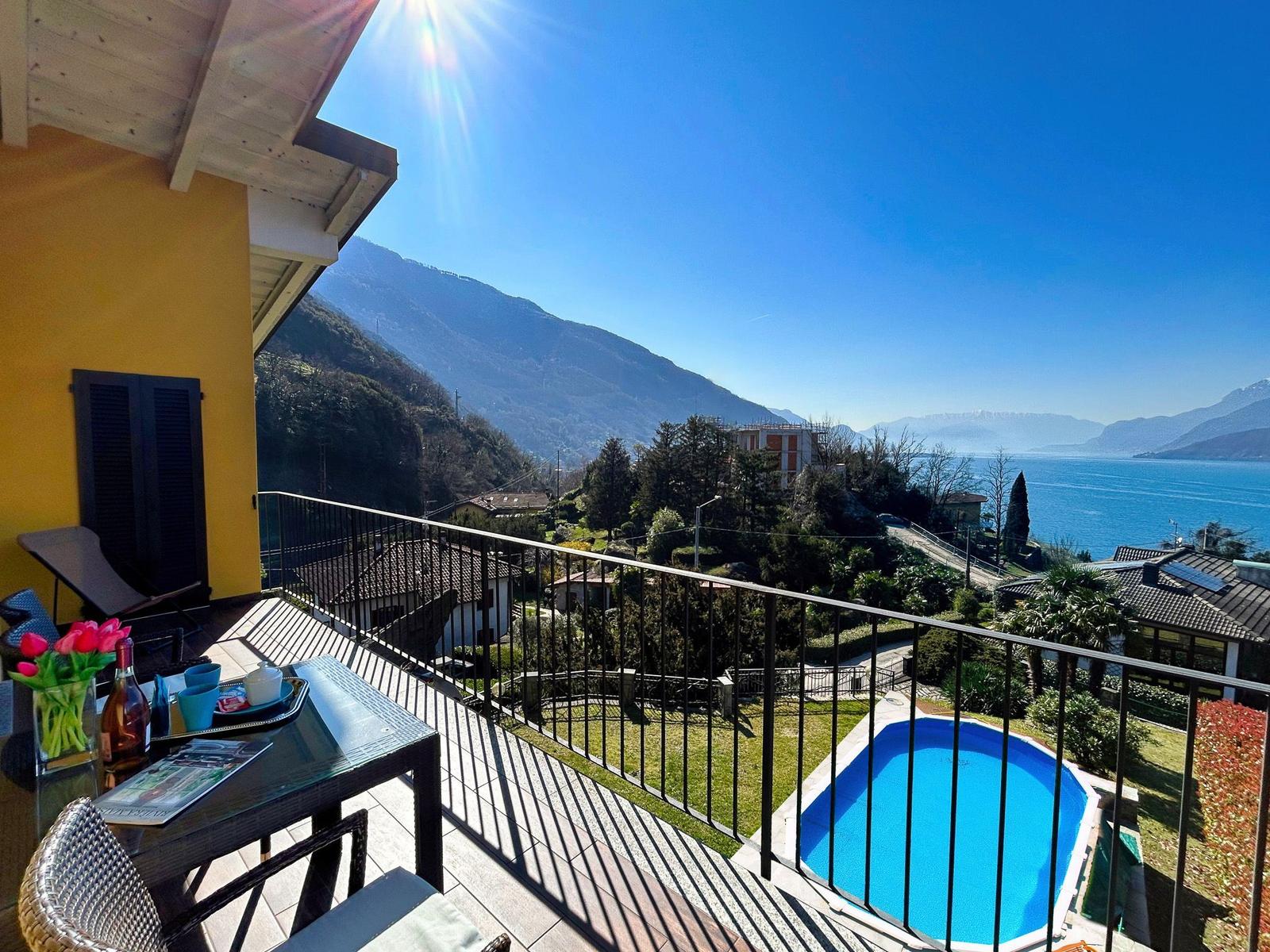 Terrasse mit Pool und Blick auf See und Berge.