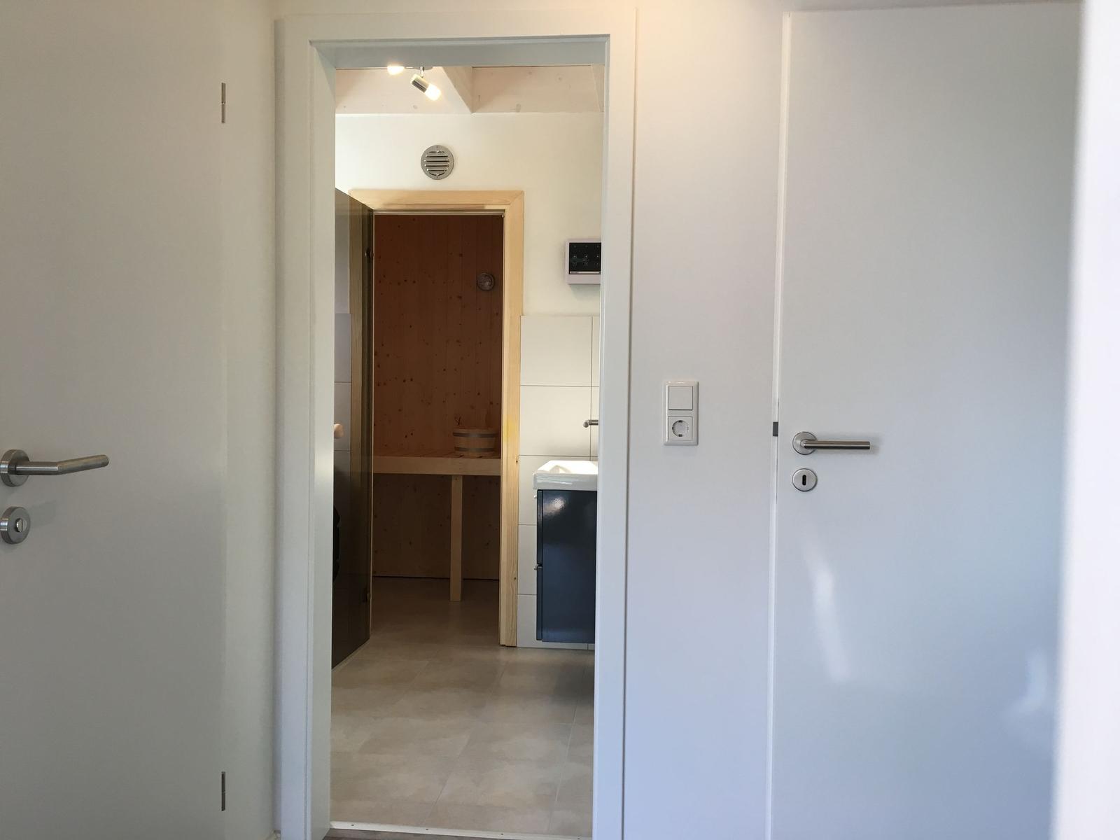 Sauna mit Holzwand und Sitzbank im Hintergrund