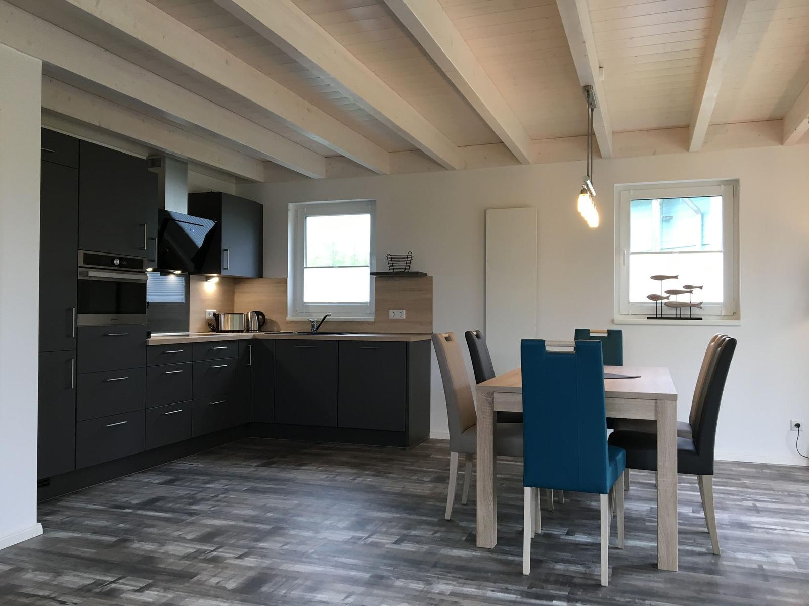 Küche mit Essbereich, Holzbalkendecke und moderner Einrichtung.