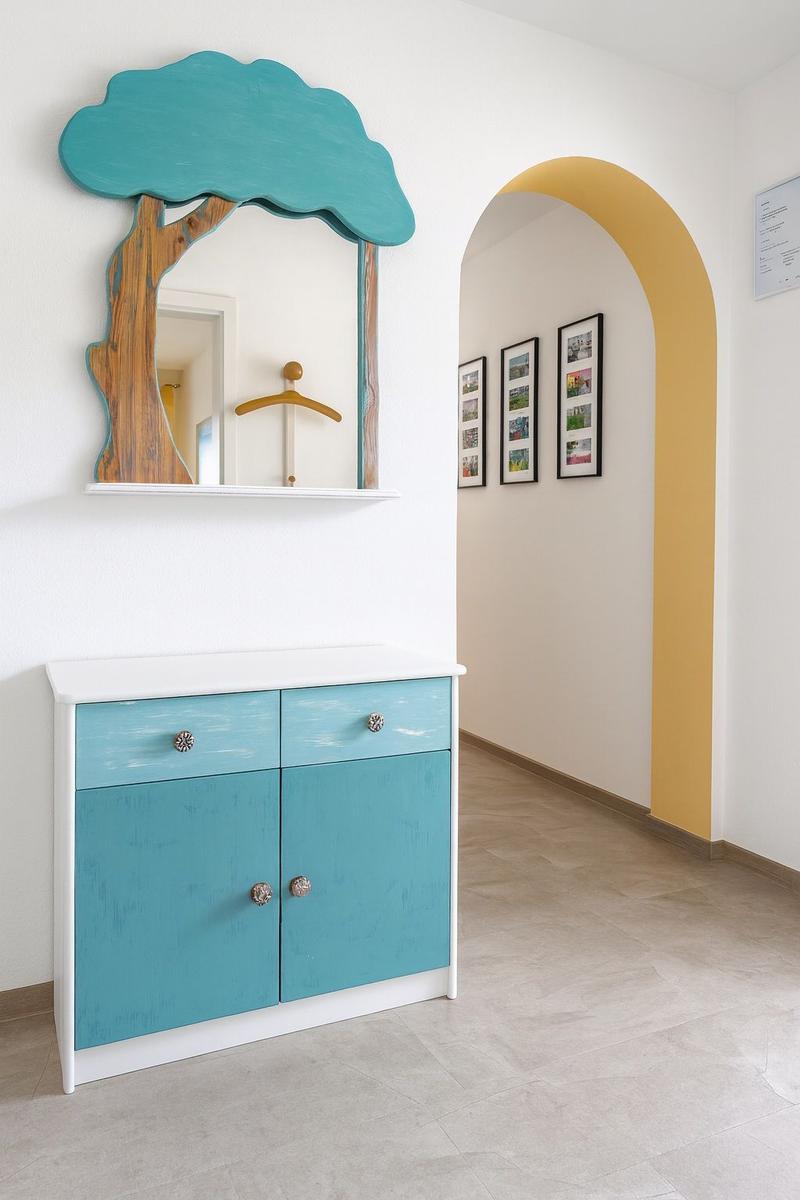Ein Schrank mit blauen Schubladen und Türen unter einem Baumspiegel. Gelber Bogen im Hintergrund.