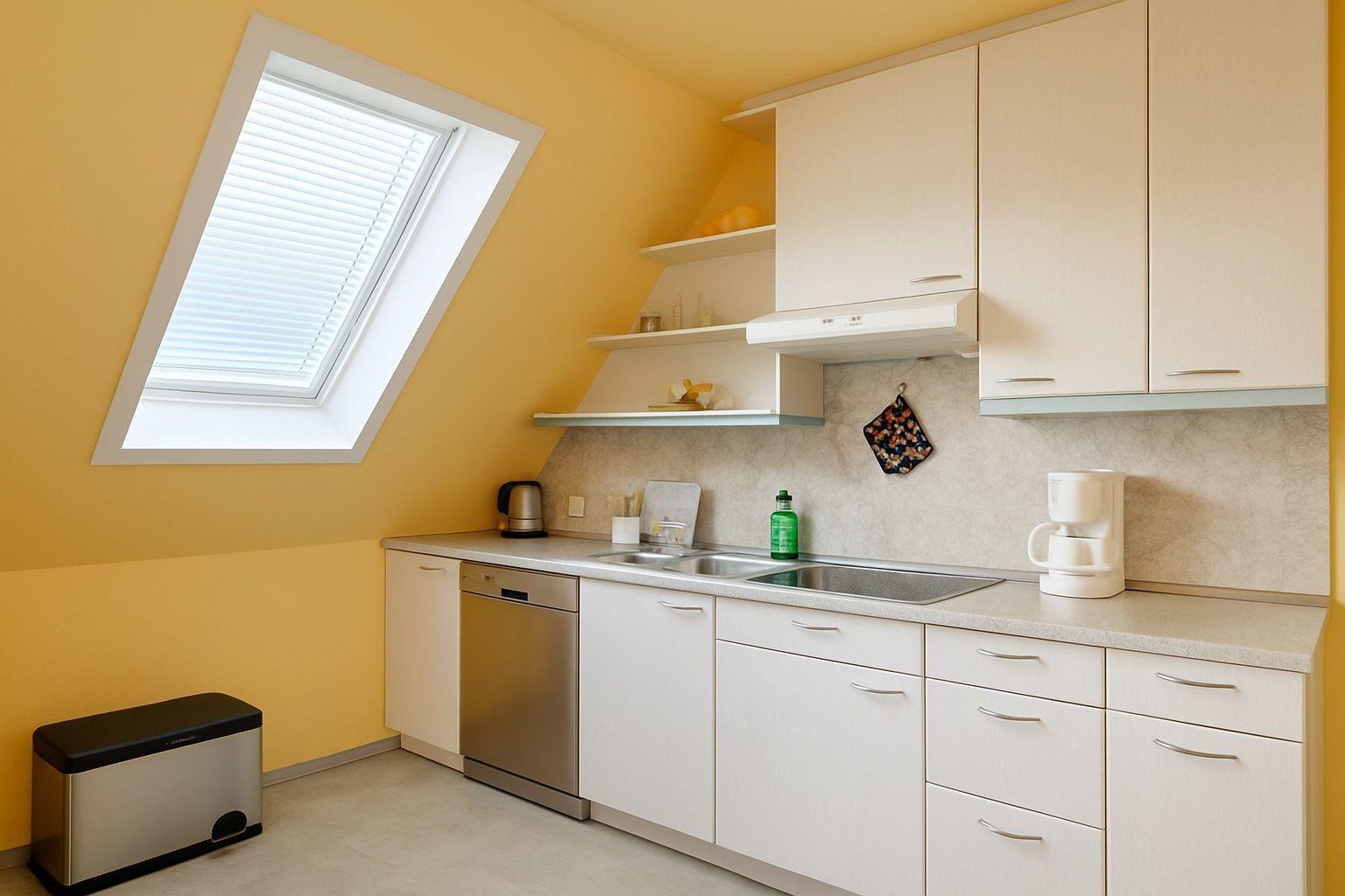 Küche mit Dachfenster, Spüle, Kaffeemaschine und Geschirrspüler.