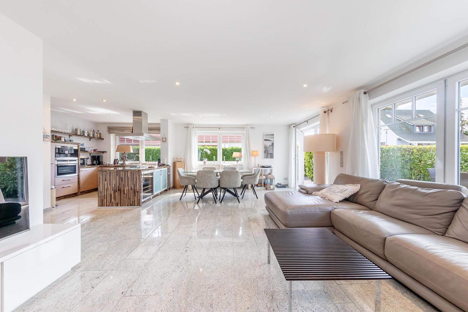 Offener Wohn- und Essbereich mit Küche und großem Fenster. Modern eingerichtet.