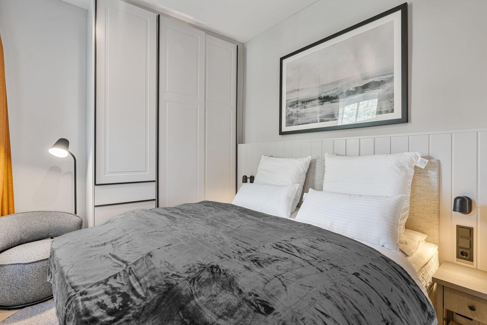 Bedroom with bed, wardrobe, and wall art.