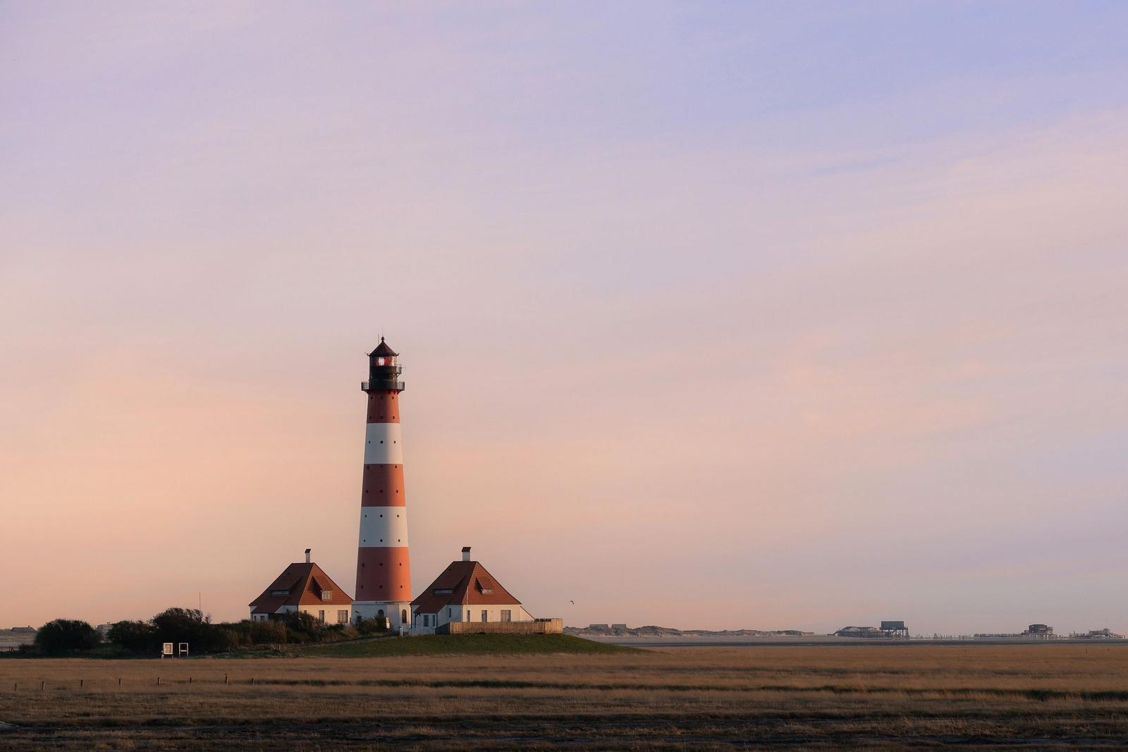 Lighthouse with red and white stripes on an island.