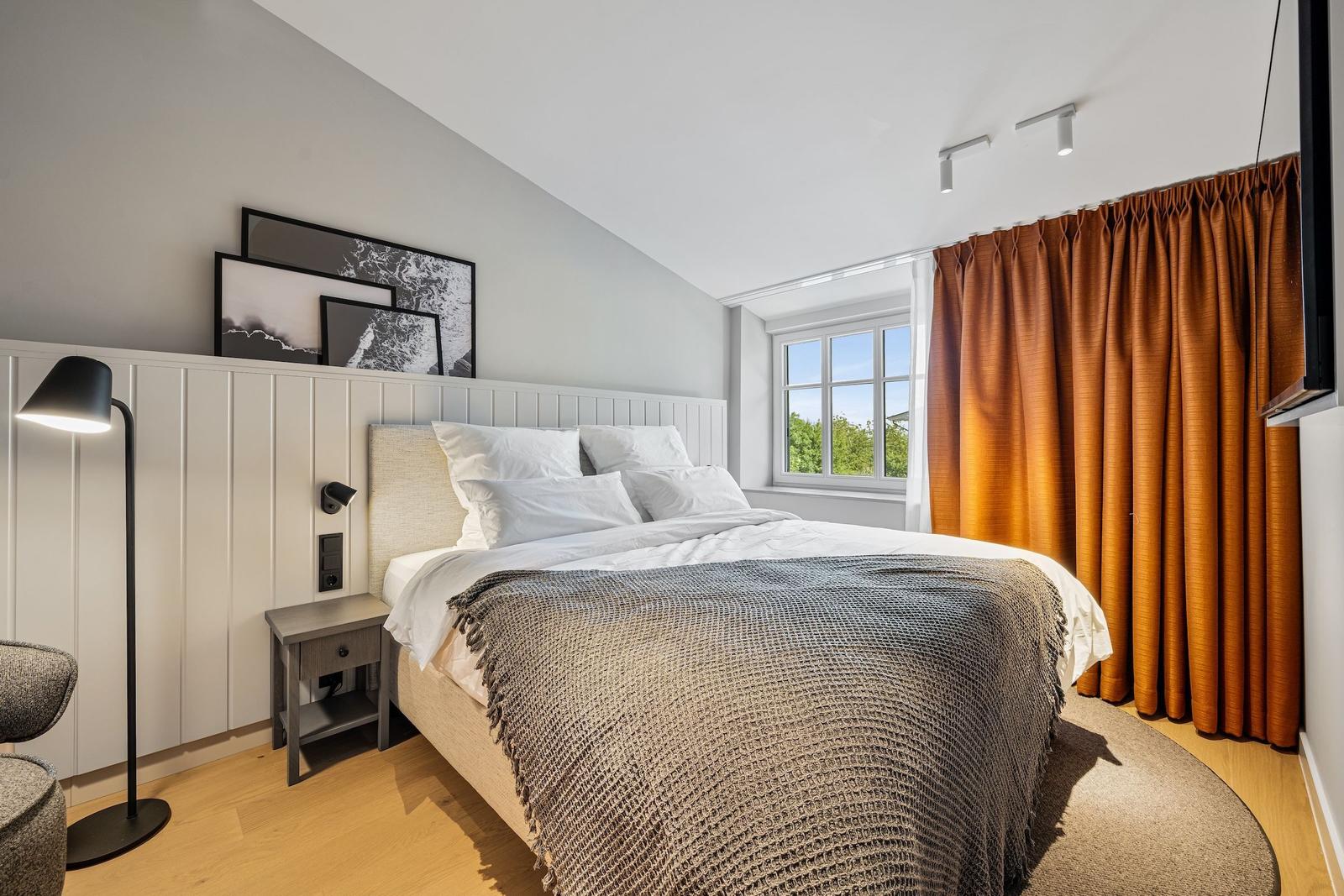 Bedroom with bed, window, and curtains