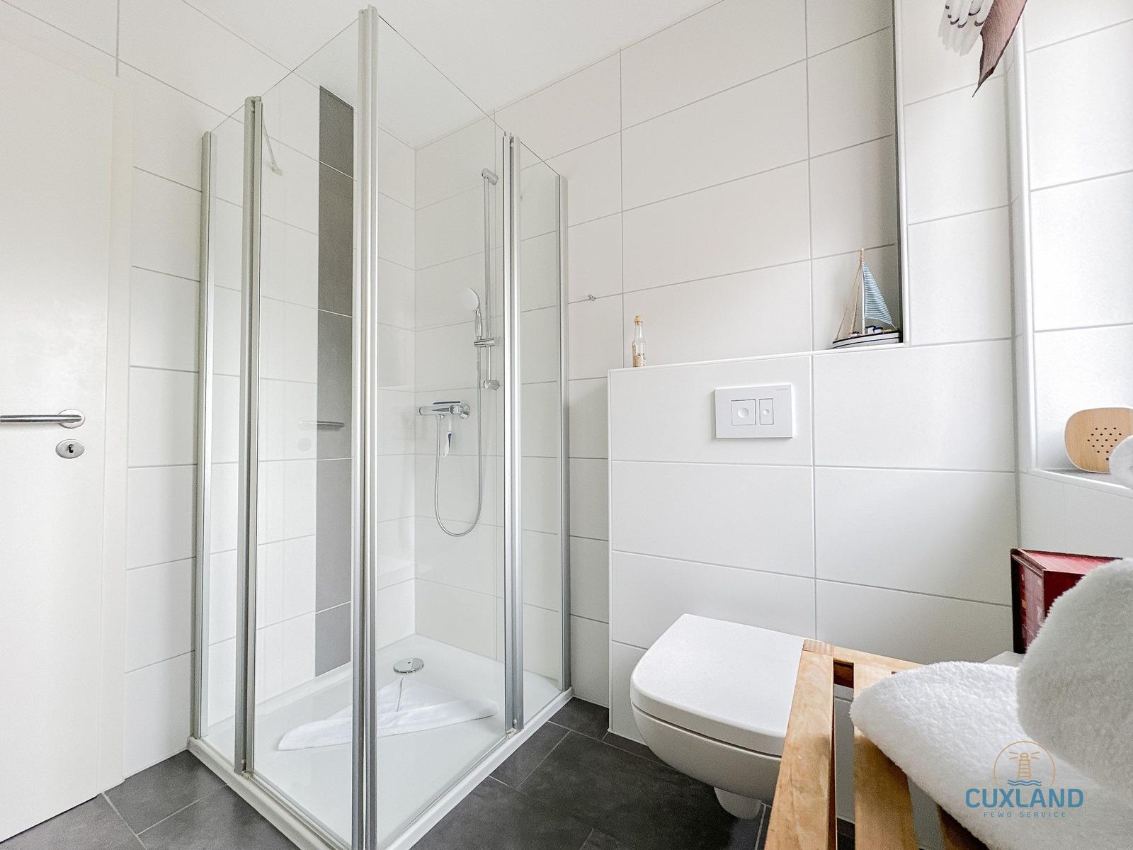 Badezimmer mit Dusche, Toilette und Fenster