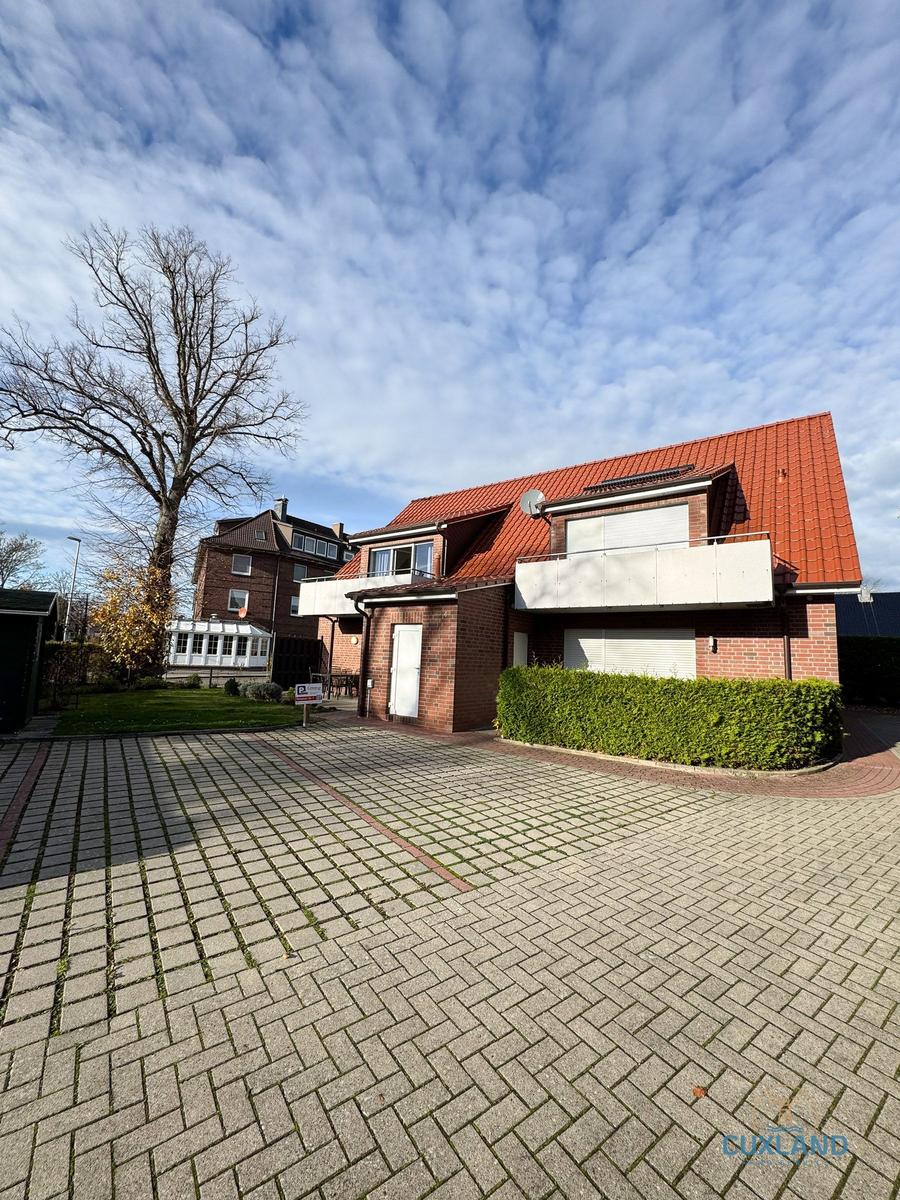 Rotes Dach, Backsteinhaus mit Balkon und gepflastertem Hof