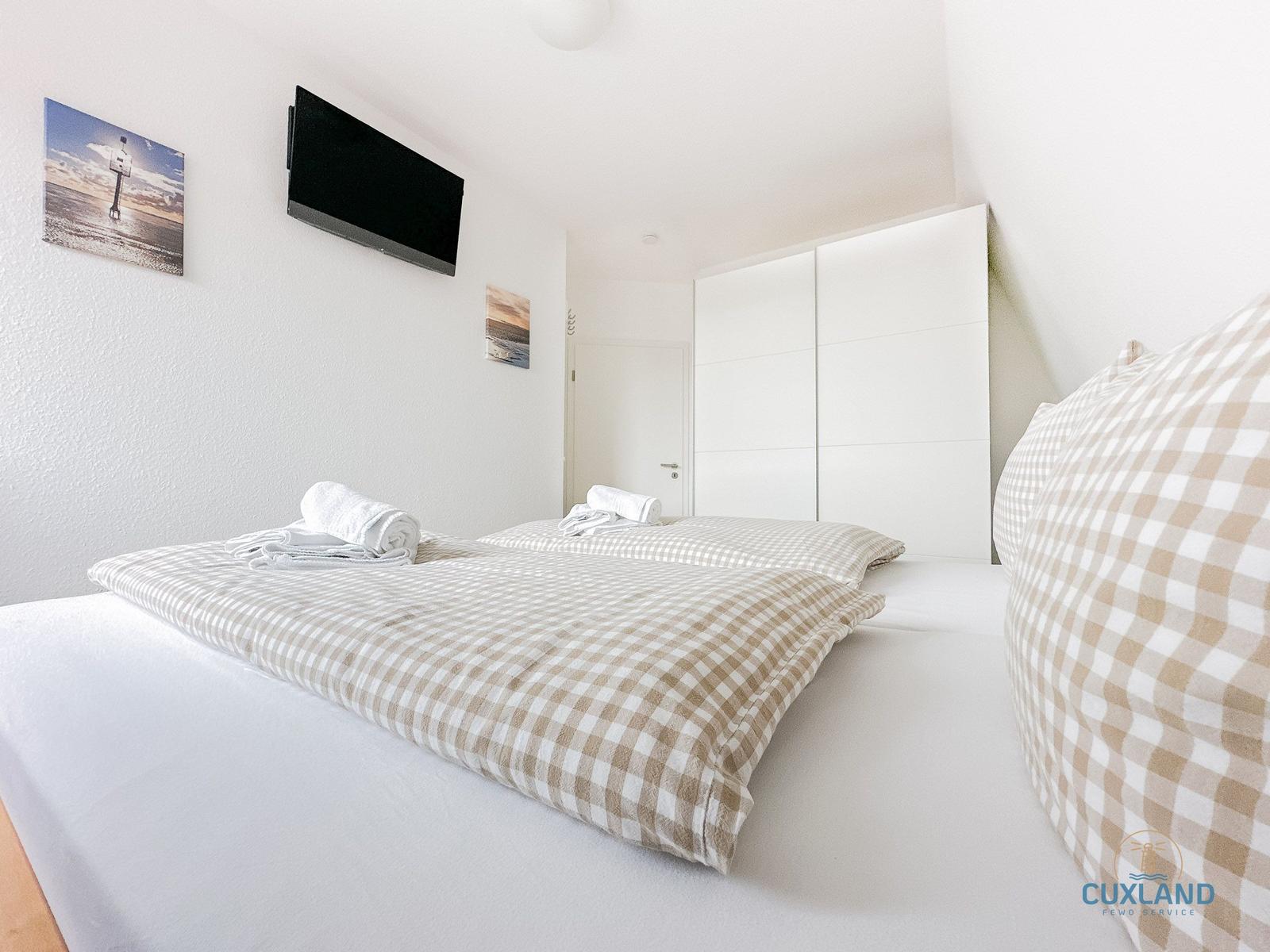 Schlafzimmer mit Doppelbett, TV und Kleiderschrank