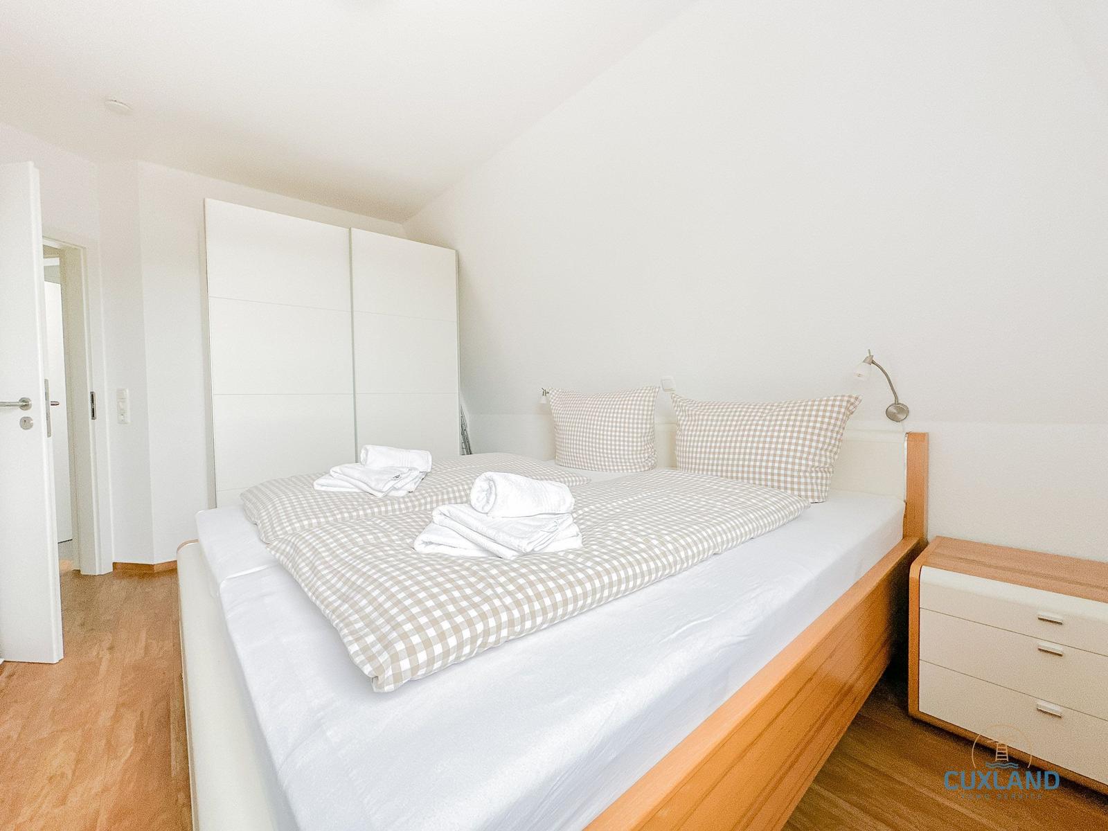 Schlafzimmer mit Doppelbett, Schrank und Nachttisch