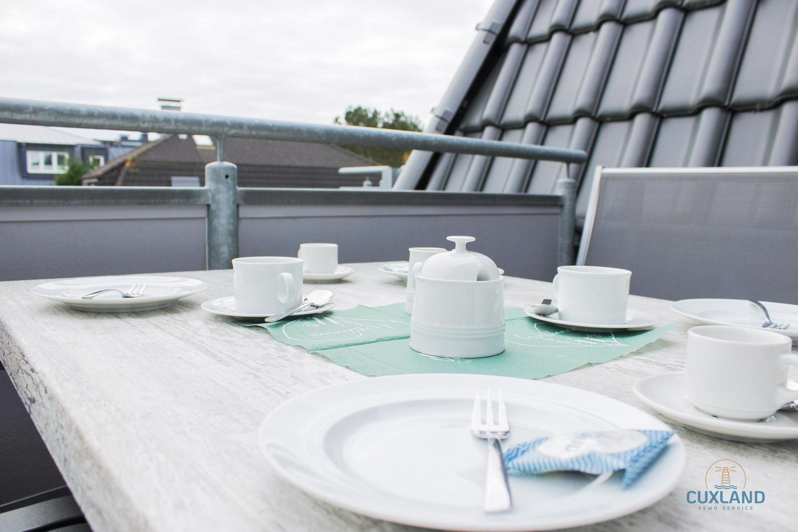 Terrasse mit gedecktem Tisch für vier Personen.