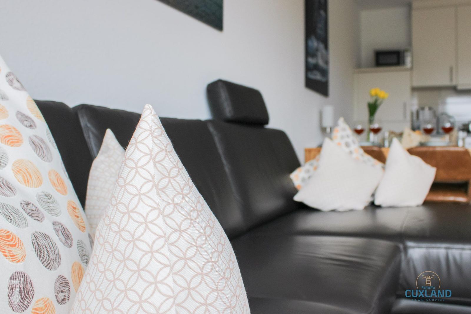 Schwarzes Sofa mit dekorativen Kissen im Wohnbereich.