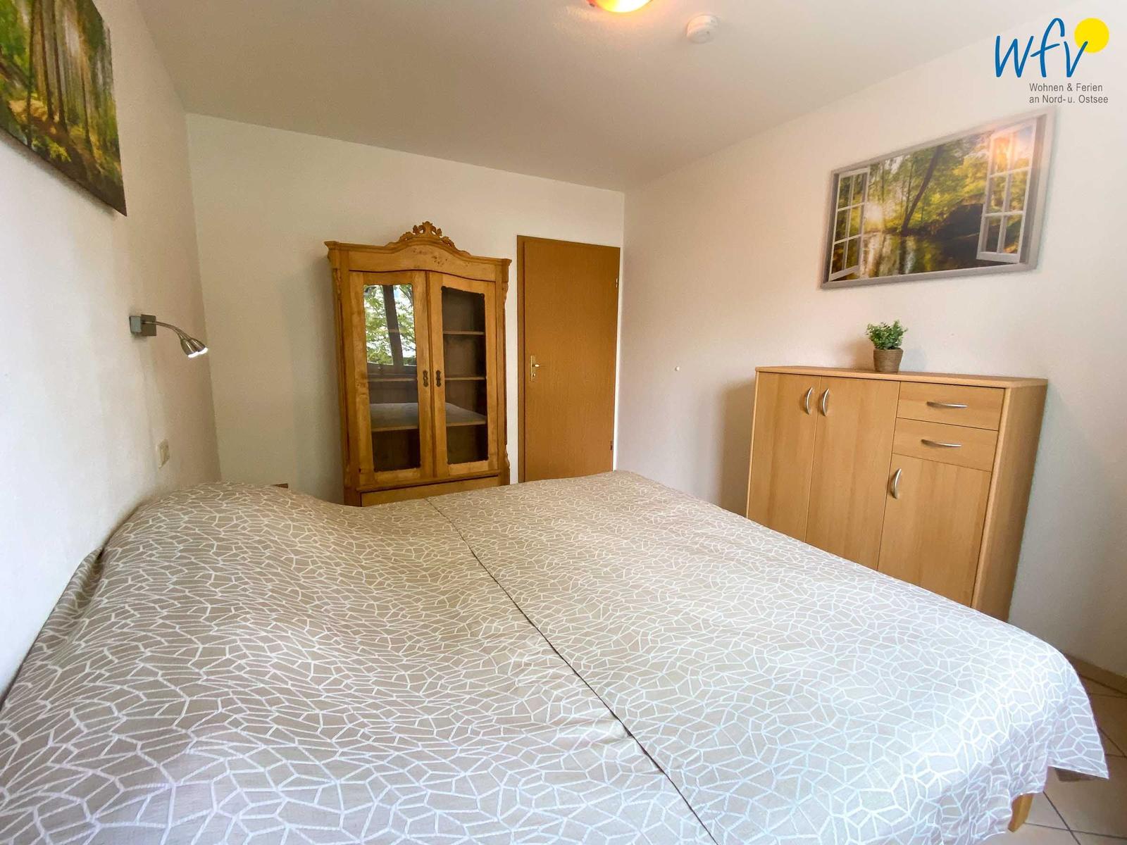 Schlafzimmer mit Bett, Schrank und Wandbild