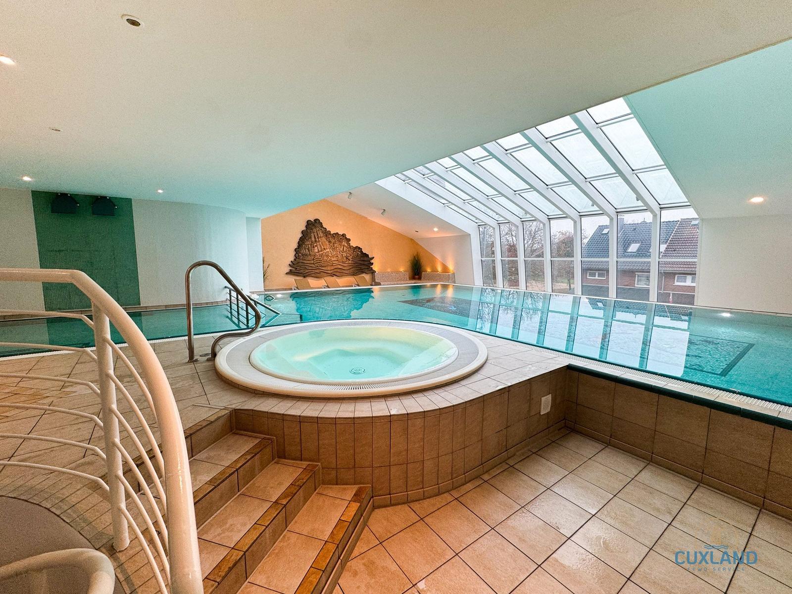 Innenpool mit Whirlpool und großem Glasdach