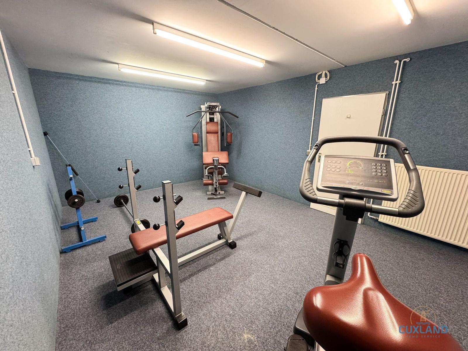 Fitnessraum mit Geräten für Kraft- und Kardiotraining.