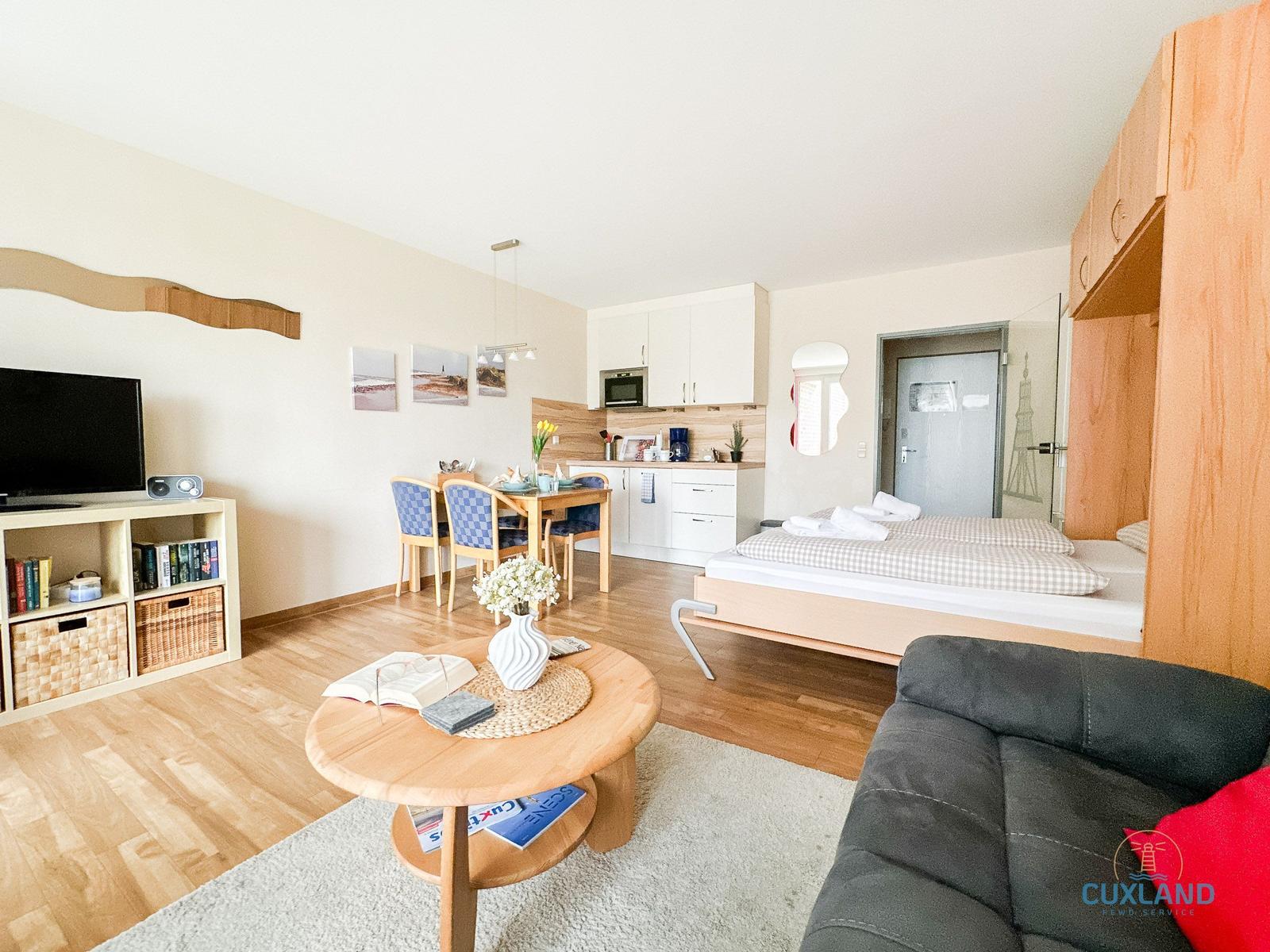 Wohnung mit Schlafbereich, Küche und Wohnzimmer. Möbel und Einrichtung sichtbar.