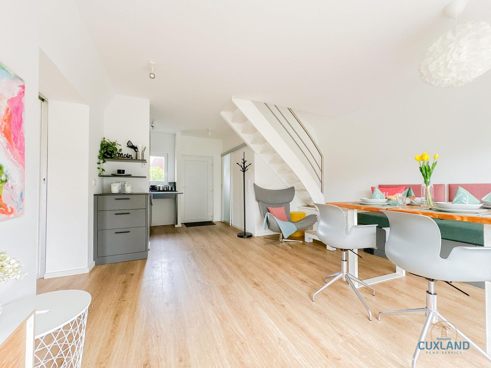 Wohn- und Essbereich mit Treppe, Stuhl und Esstisch.