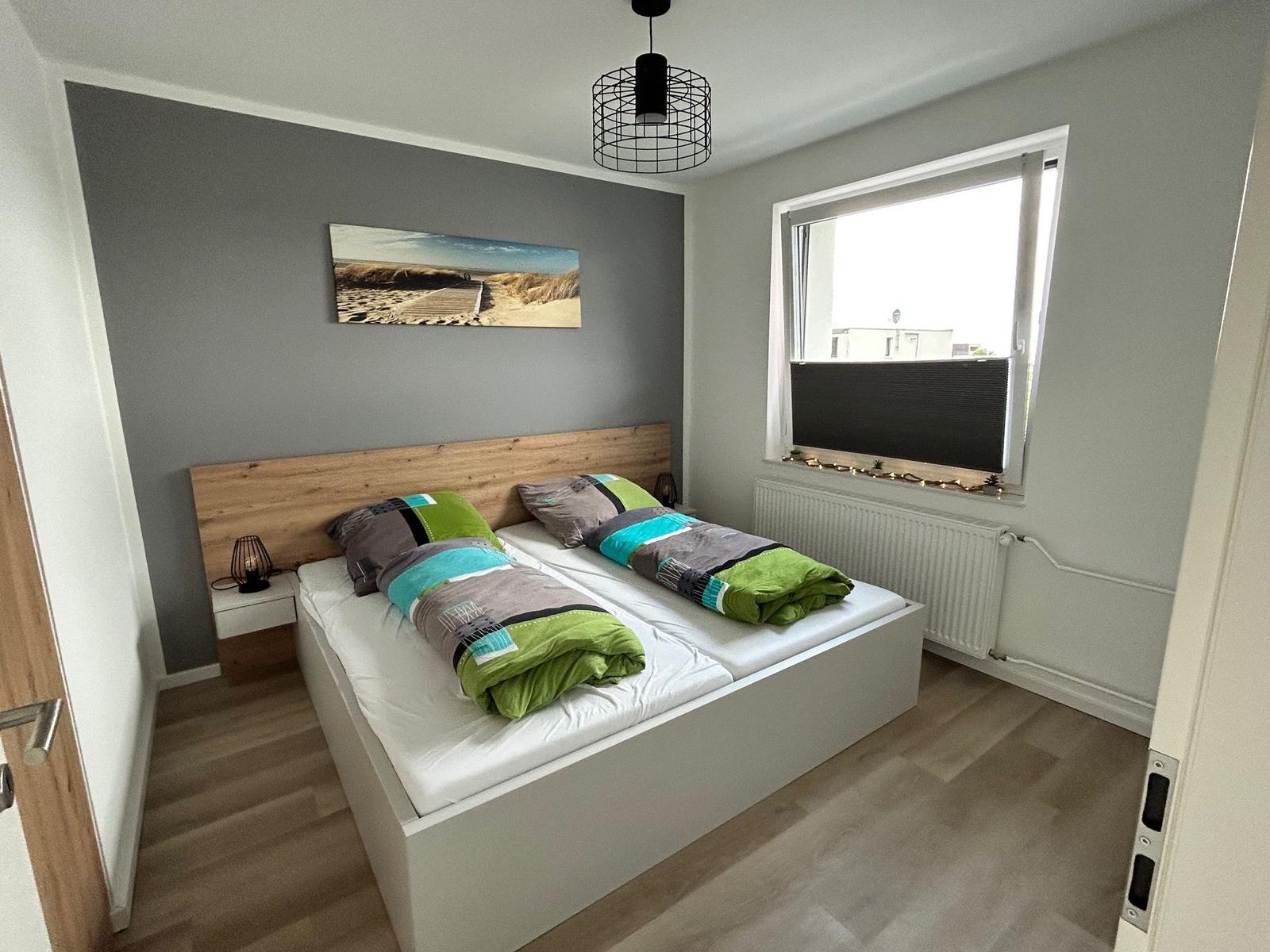 Schlafzimmer mit Doppelbett, Holzfußboden und Fenster mit Blick.