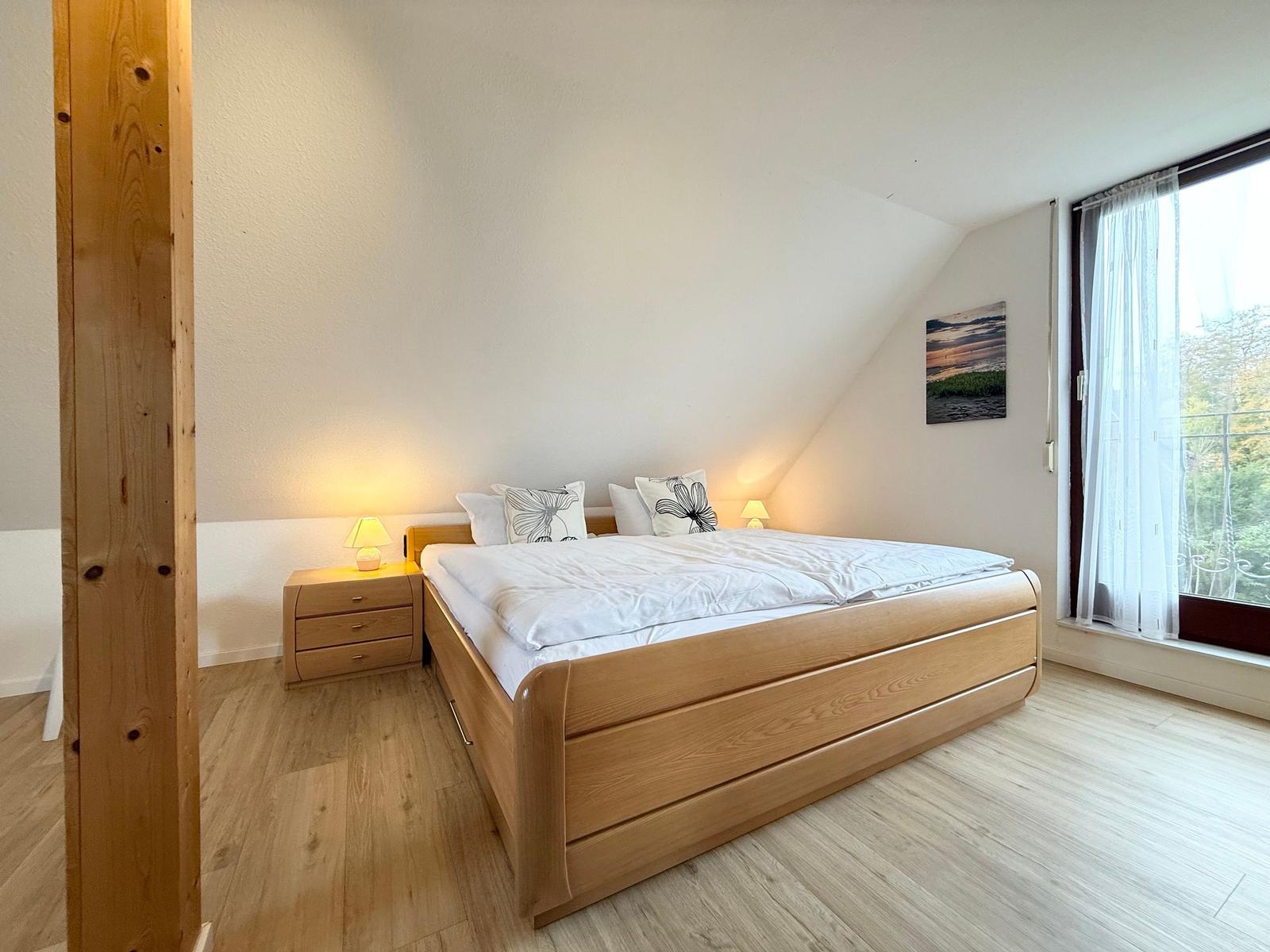 Bedroom with double bed, nightstand, and window with view.