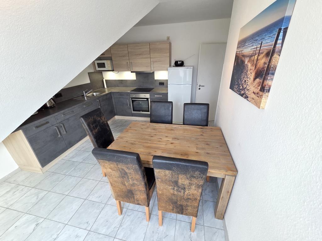 Küche mit Essbereich, Holztisch und Stühle unter schräger Decke
