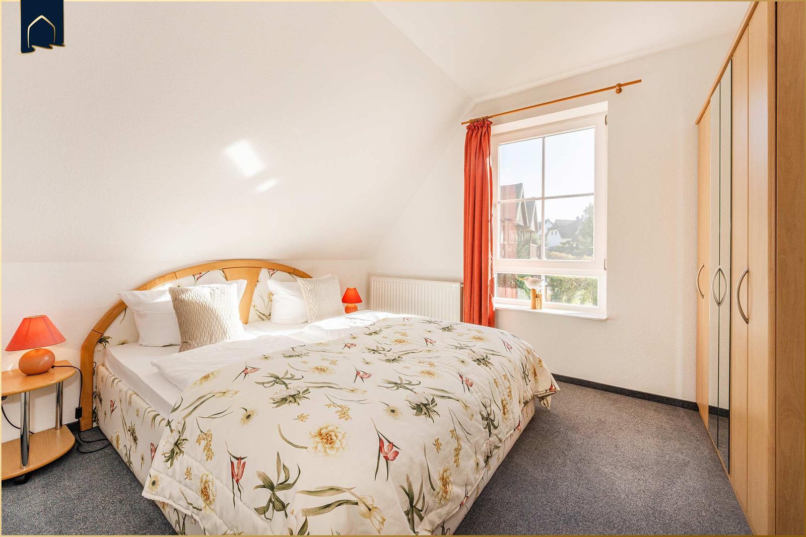 Schlafzimmer mit Doppelbett, Fenster und Kleiderschrank