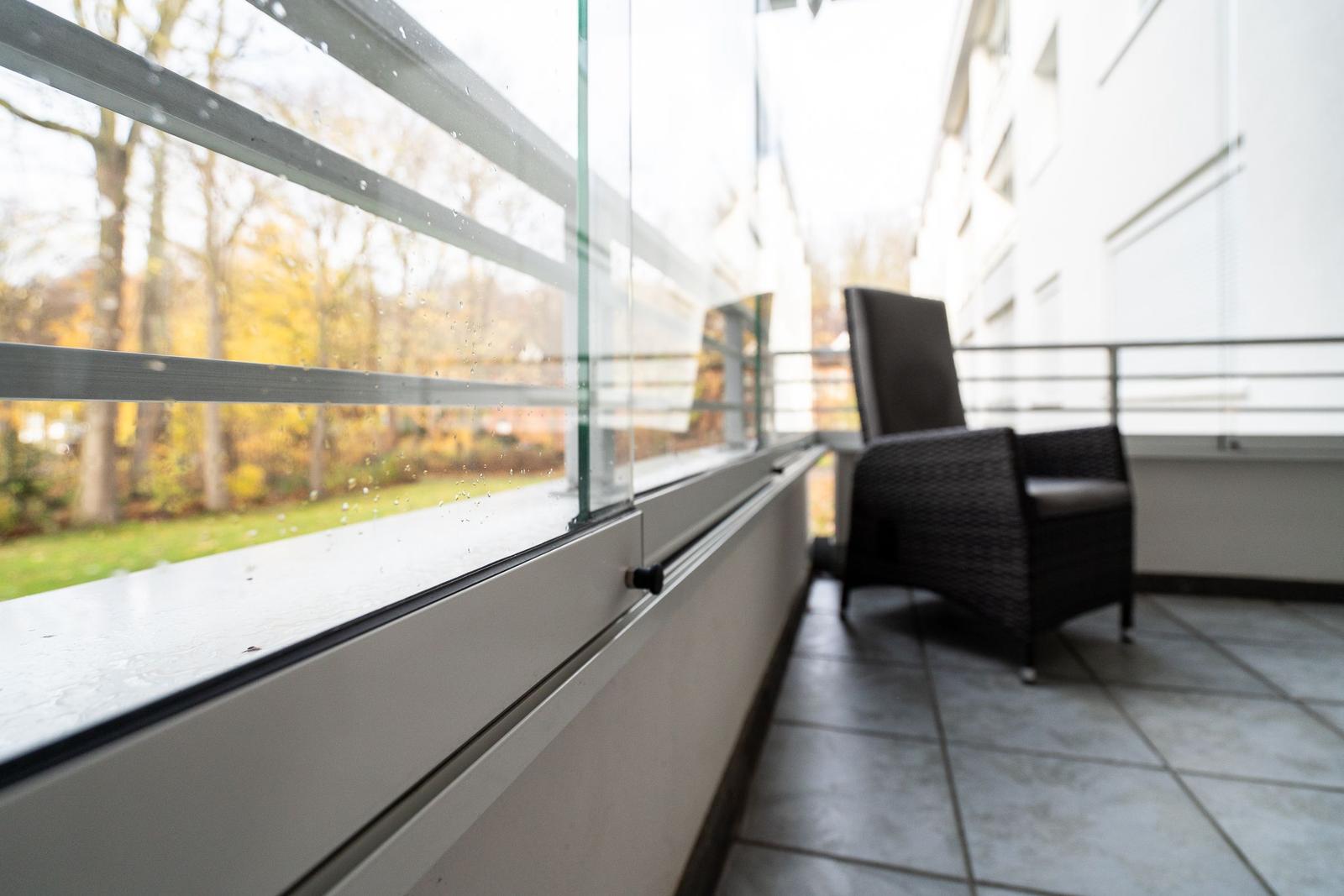 Terrasse mit Sitzgelegenheit und Blick auf einen Park.