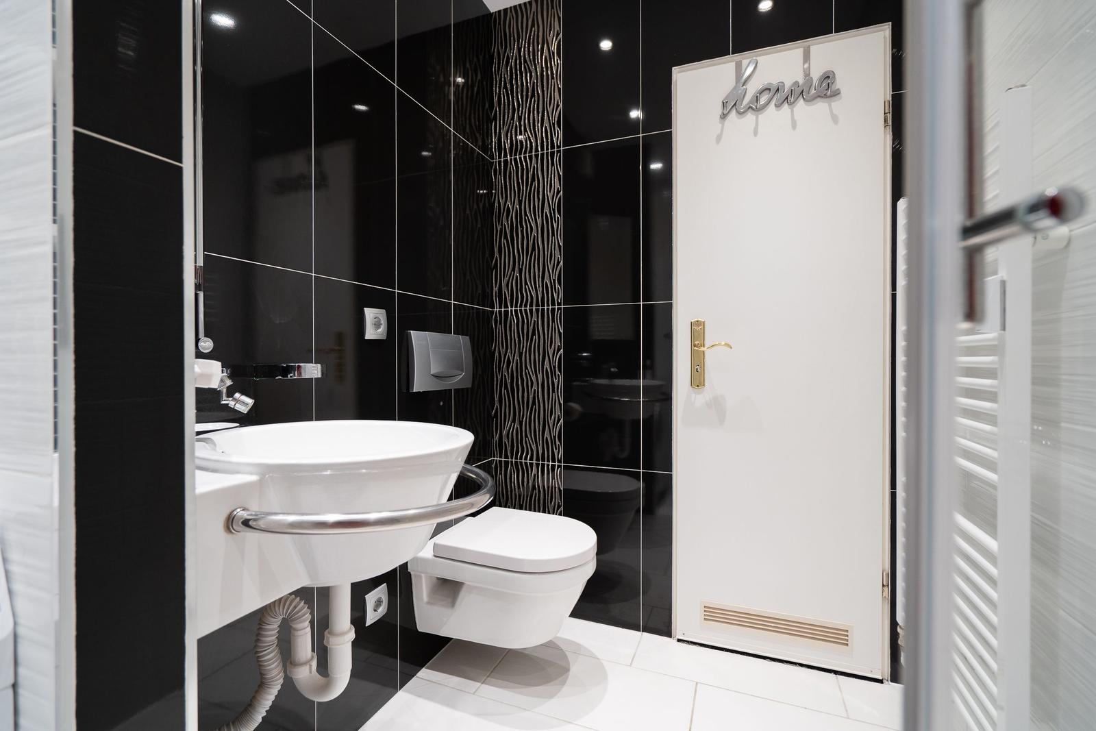 Dusche mit Duschwanne, Toilette und Waschbecken mit modernem Design.