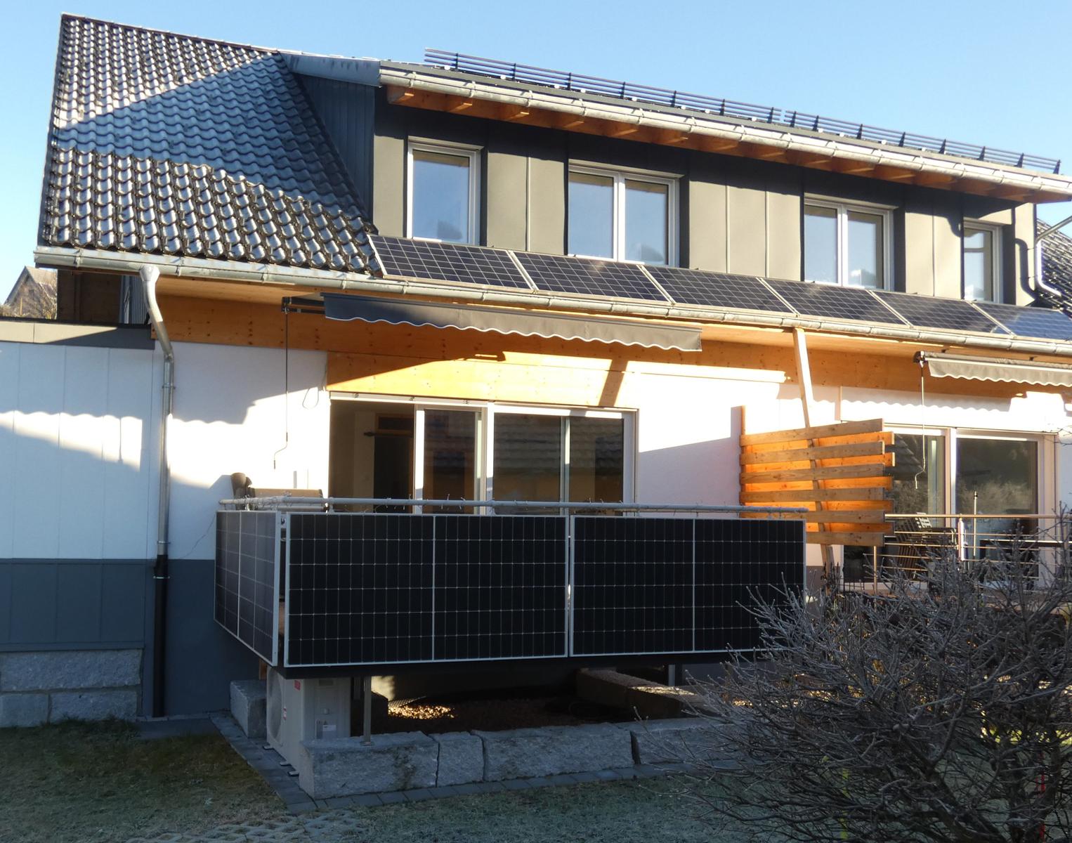 Moderne Ferienwohnung mit Solaranlagen und Balkon. Außenbereich mit Holzverkleidung.