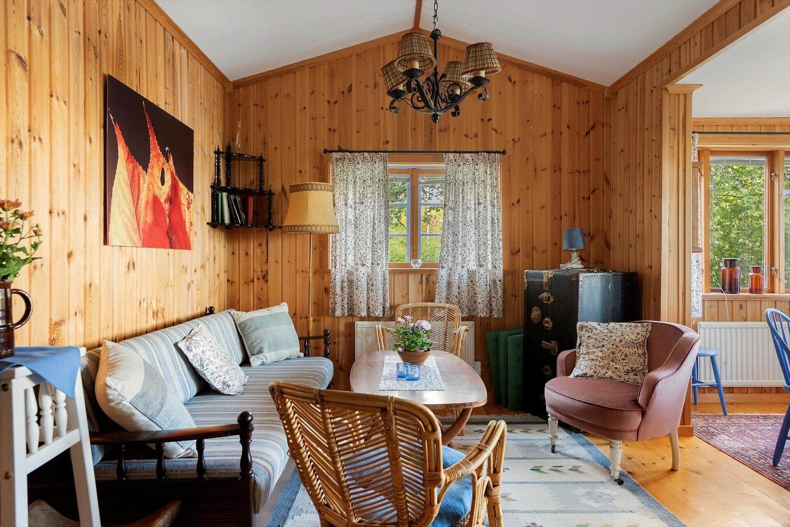 Wohnzimmer mit Holzwand, Sofa, Stuhl und Tisch