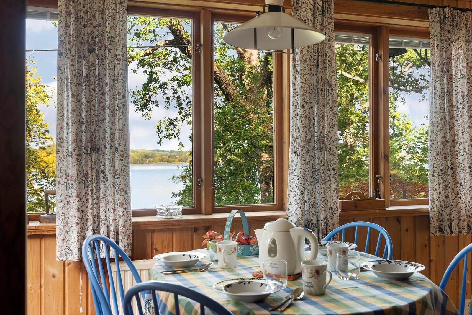Esszimmer mit Tisch, Stühlen und Blick auf See