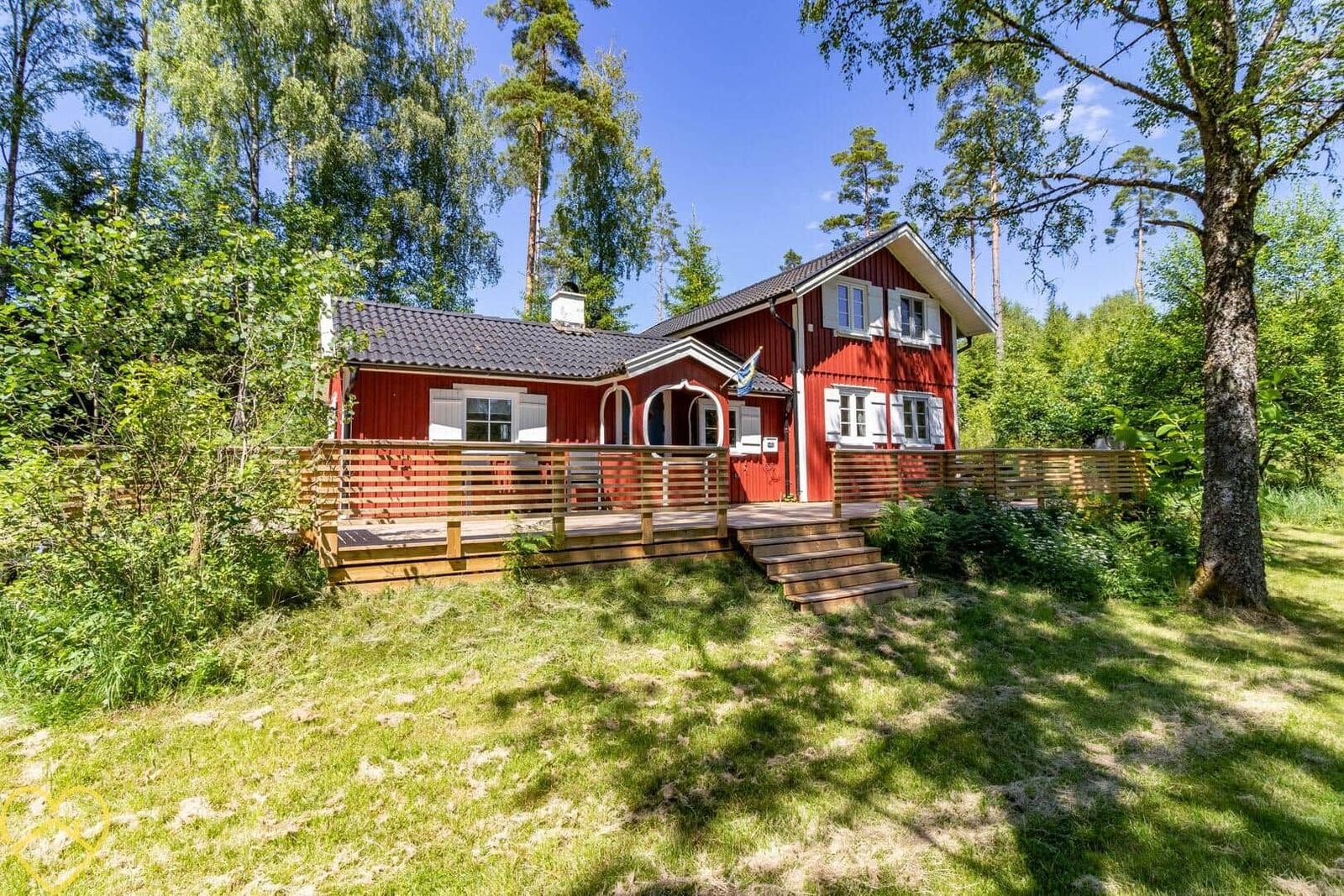Rotes Holzhaus mit Terrasse und Umgebung im Wald