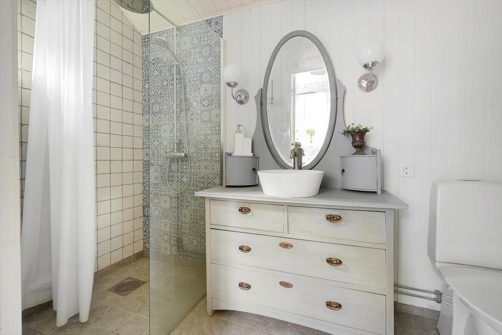 Badezimmer mit Dusche, Waschtisch und Toilette.