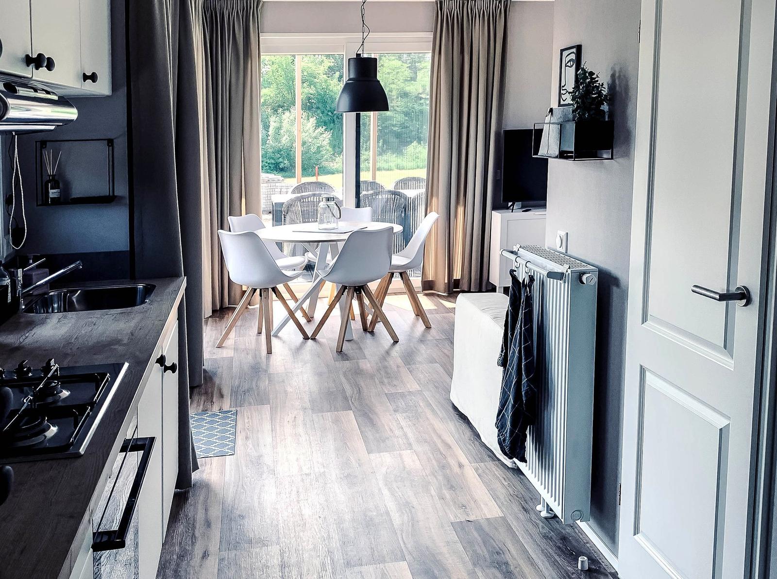 Küche mit Esstisch, Fernseher und Blick auf Garten