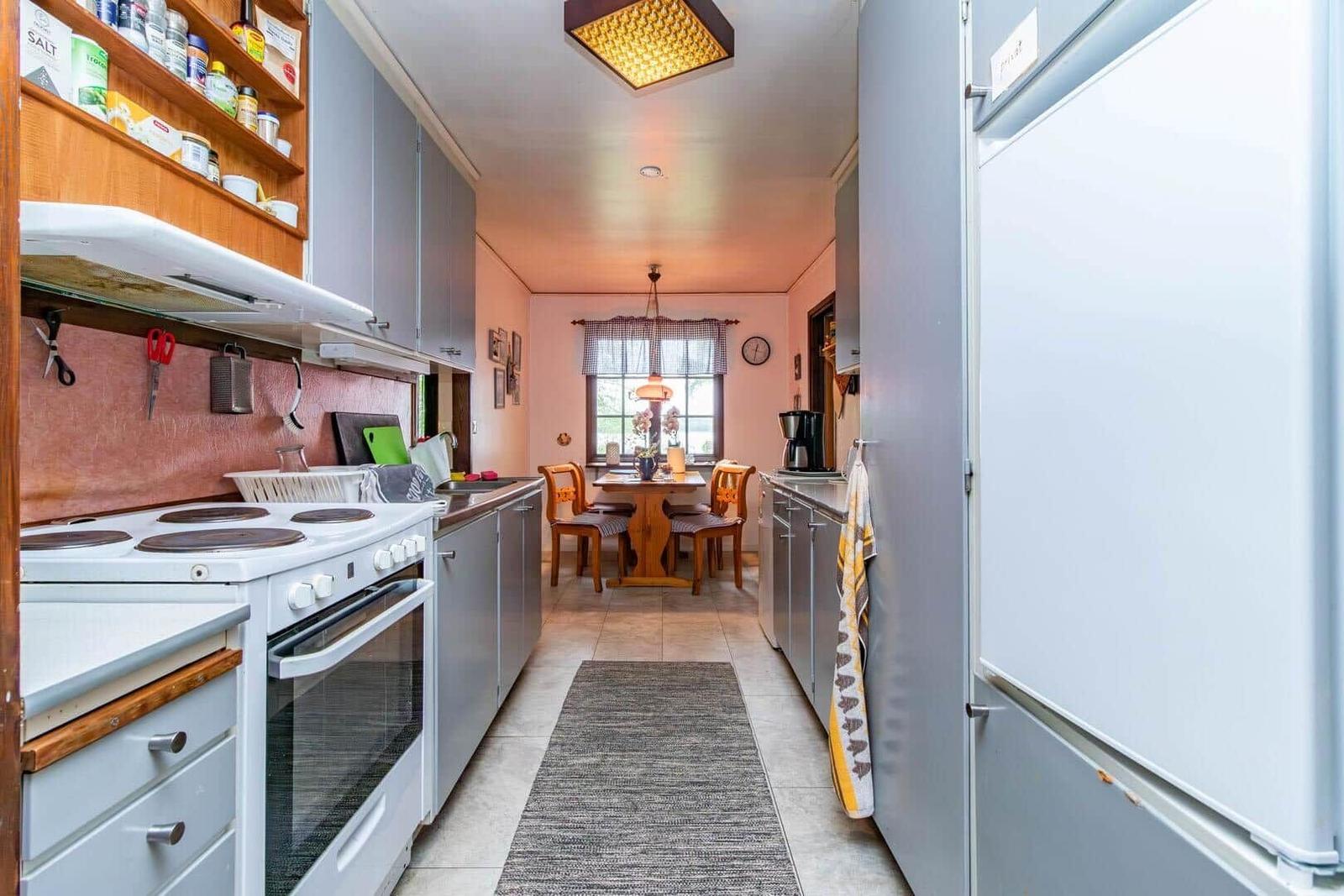 Küche mit Essbereich, Küchenschränke, Herd und Kühlschrank.