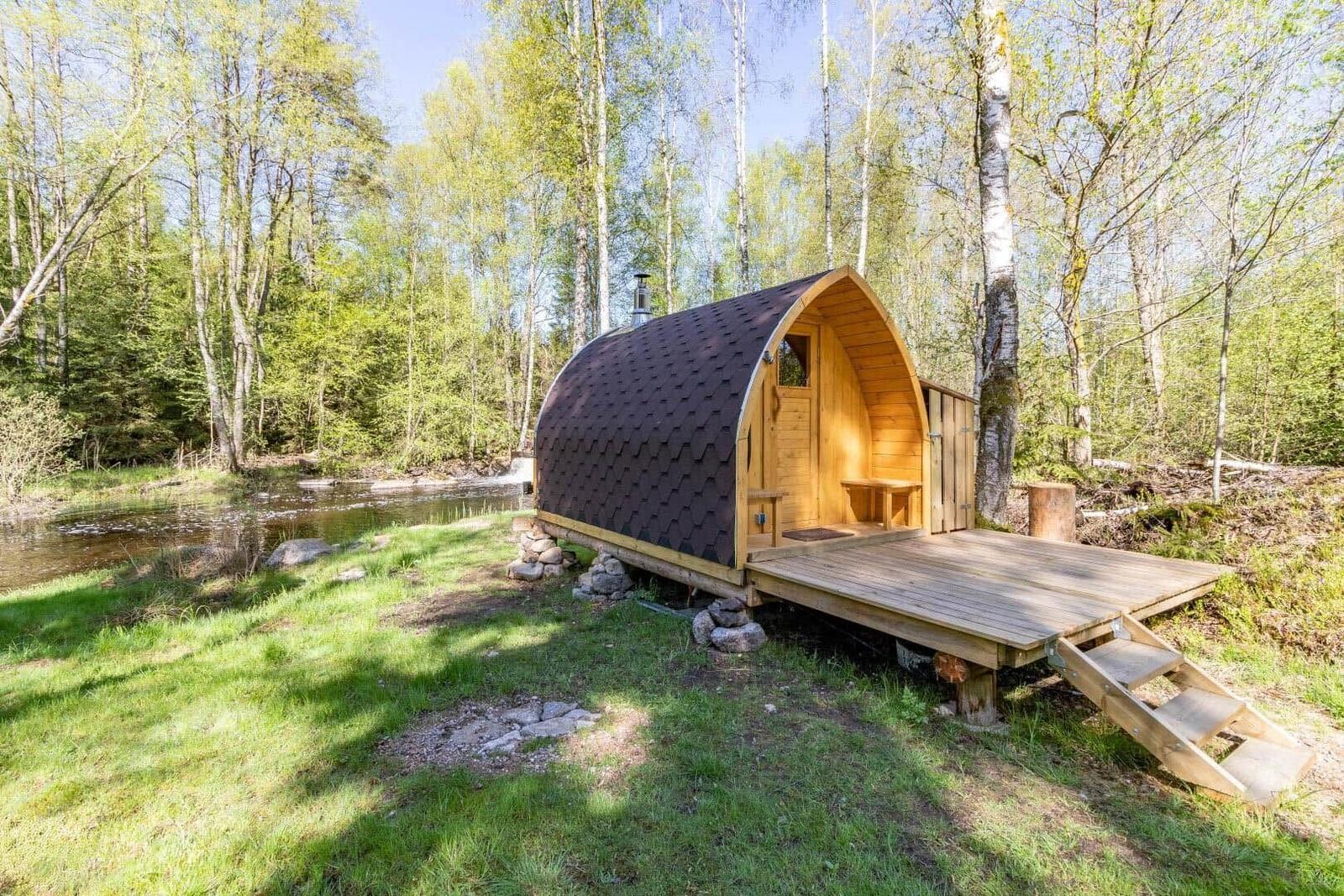 Holzhütte mit Terrasse am Fluss im Wald