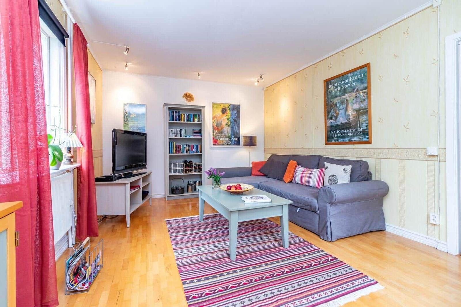Wohnzimmer mit Sofa, Couchtisch und Wandbildern.