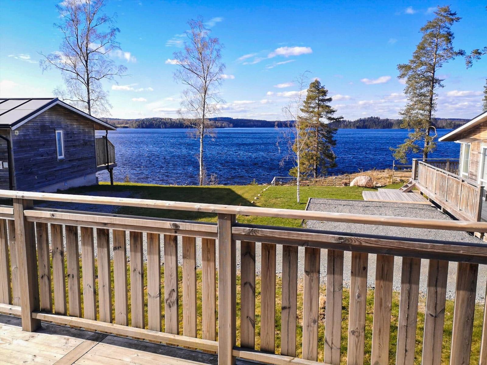 Holzterrasse mit Blick auf See und Bäume