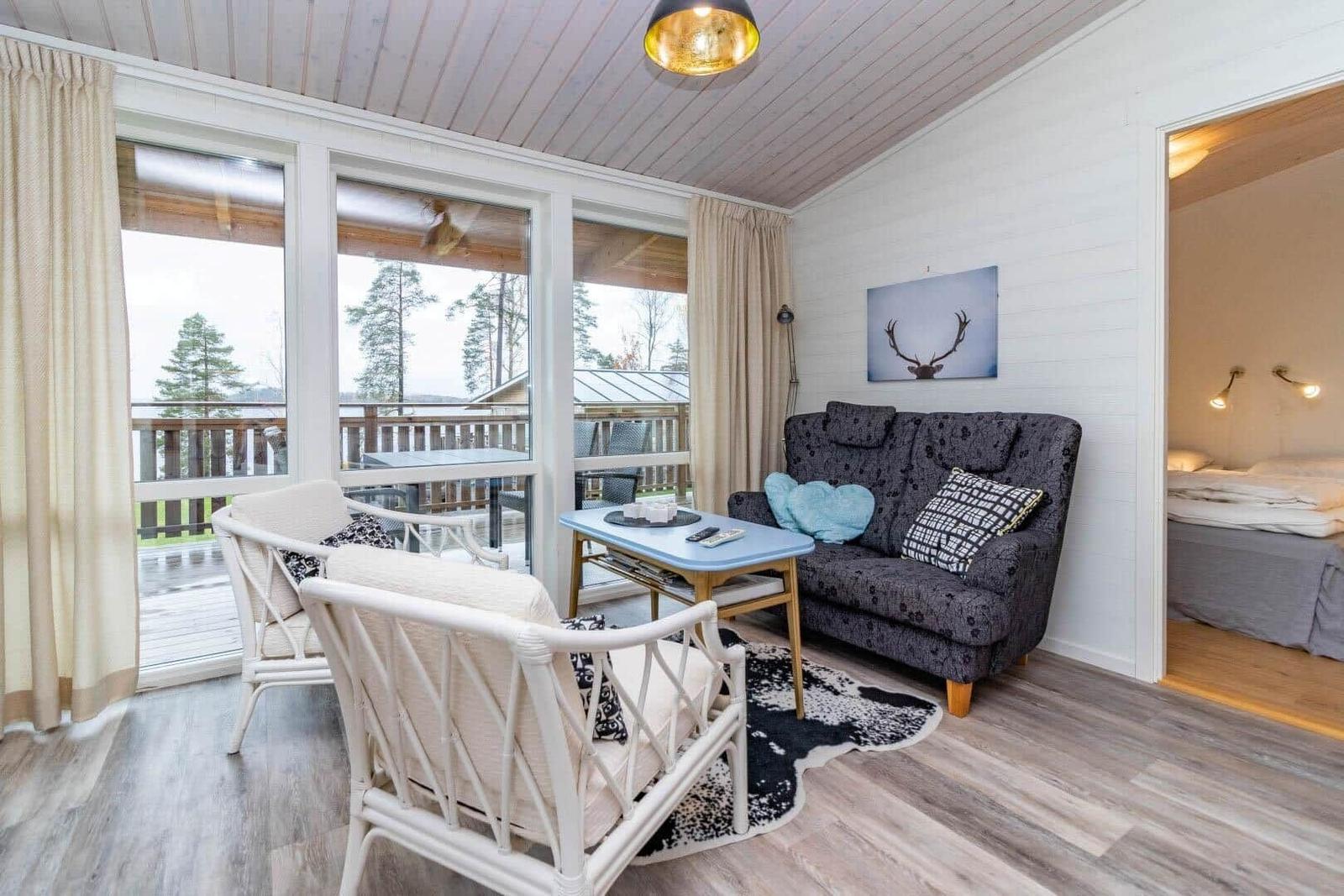 Wohnbereich mit Sofa, Sitzgelegenheiten und Blick auf Balkon.