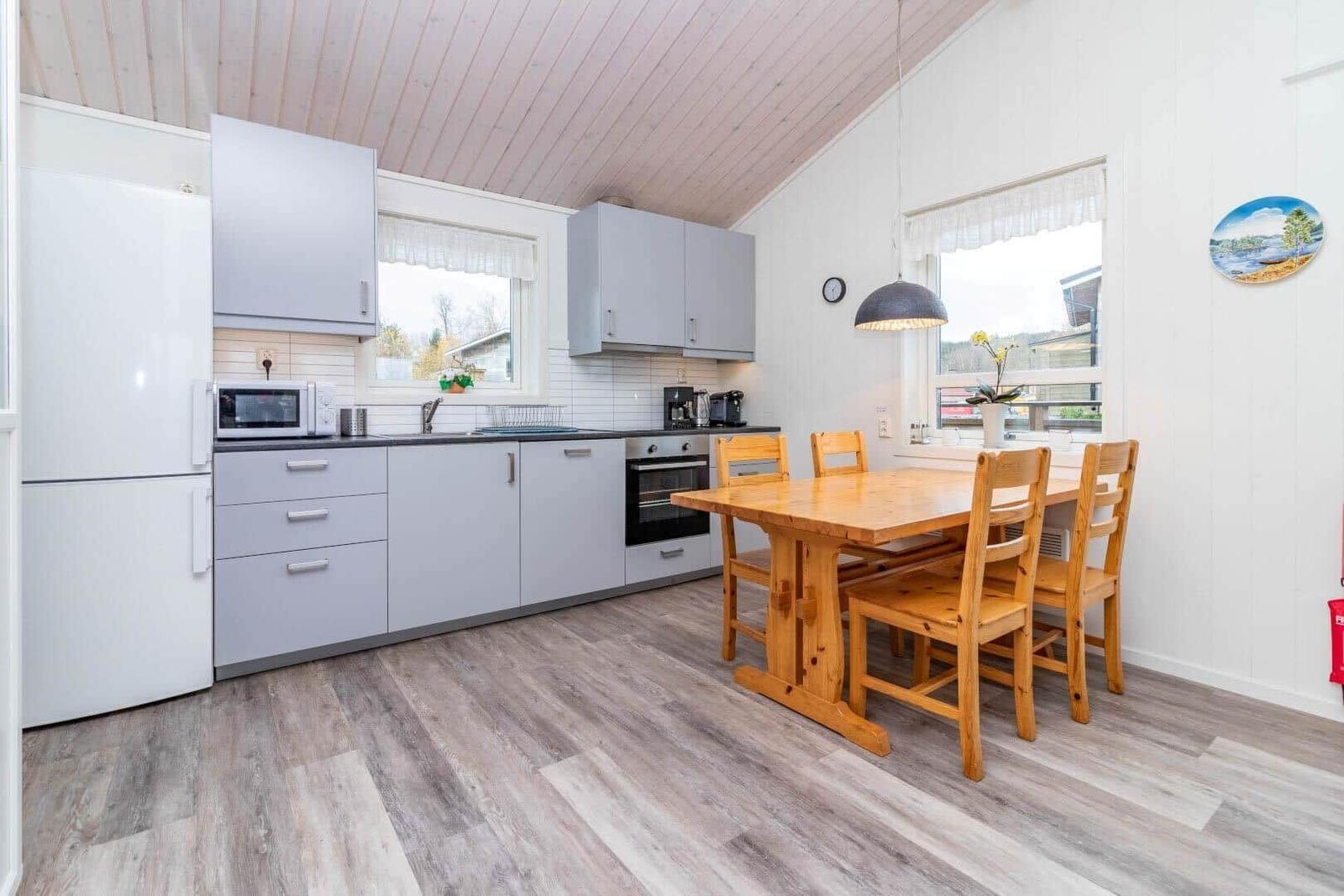 Küche mit Essbereich, Holztisch, Stühle und Küchengeräte.