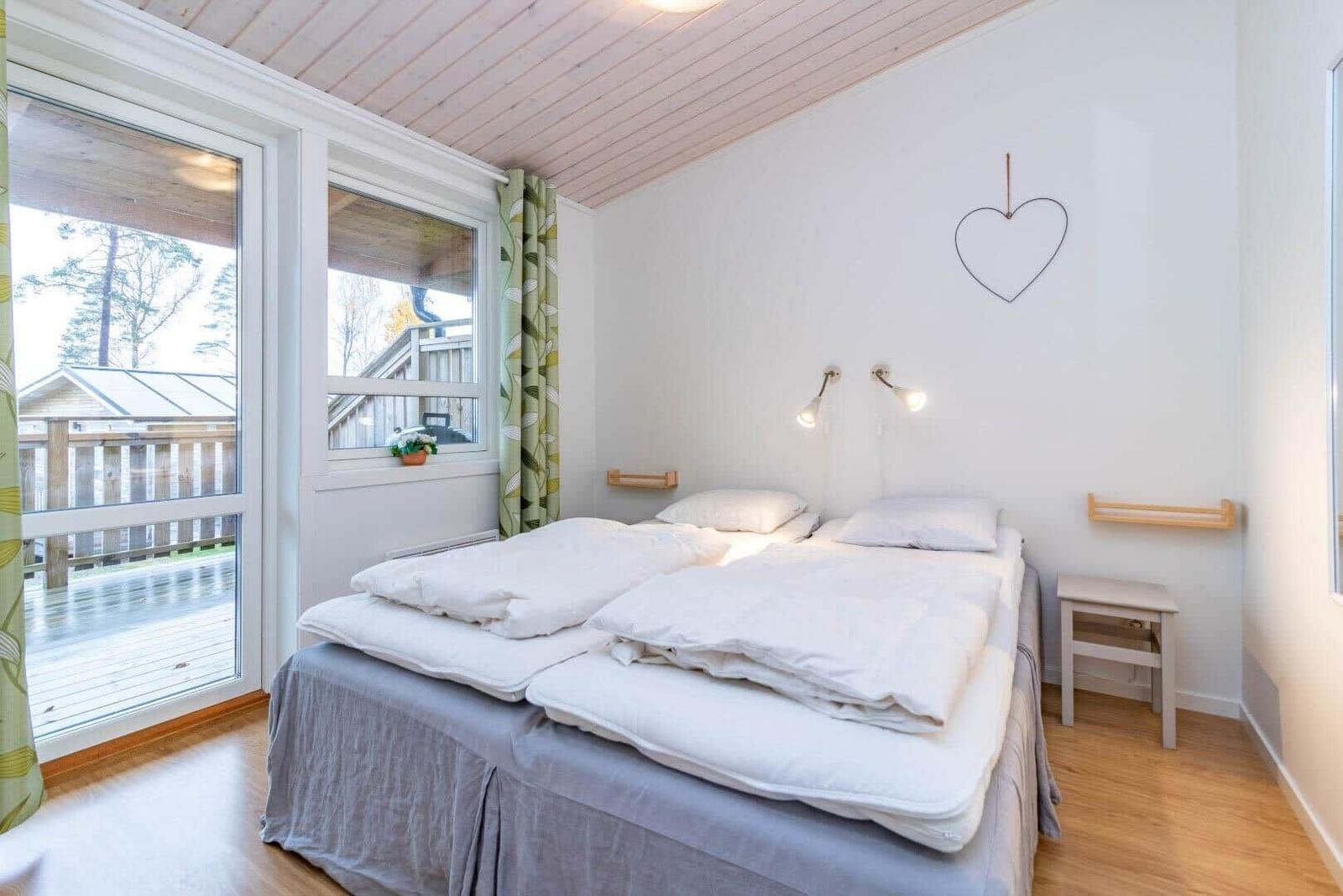 Schlafzimmer mit Doppelbett, Fenster und Herz an der Wand.