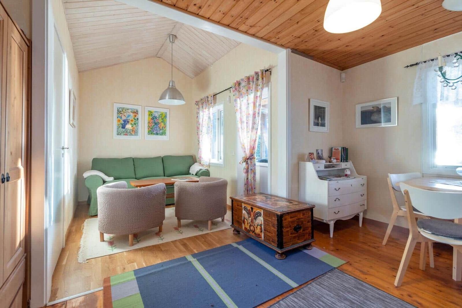 Wohn- und Essbereich mit Sofa, Stühlen und Holzboden.