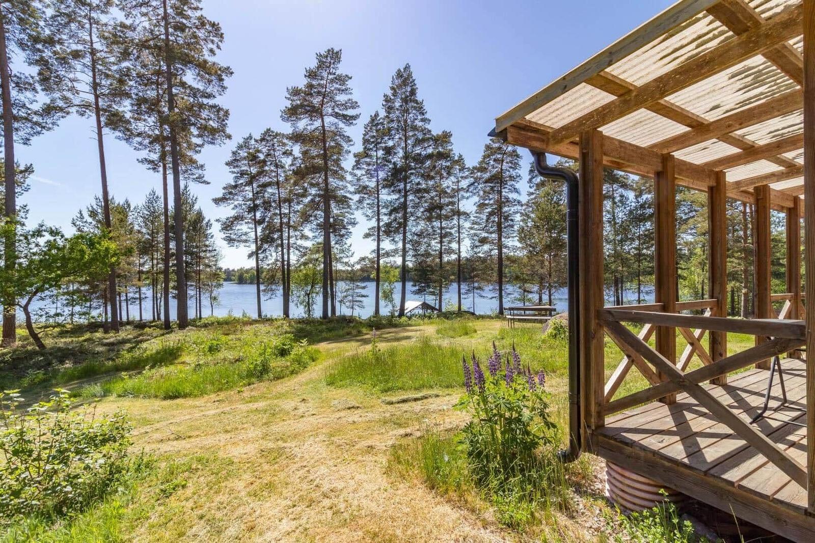 Holzveranda mit Blick auf See und Wald.