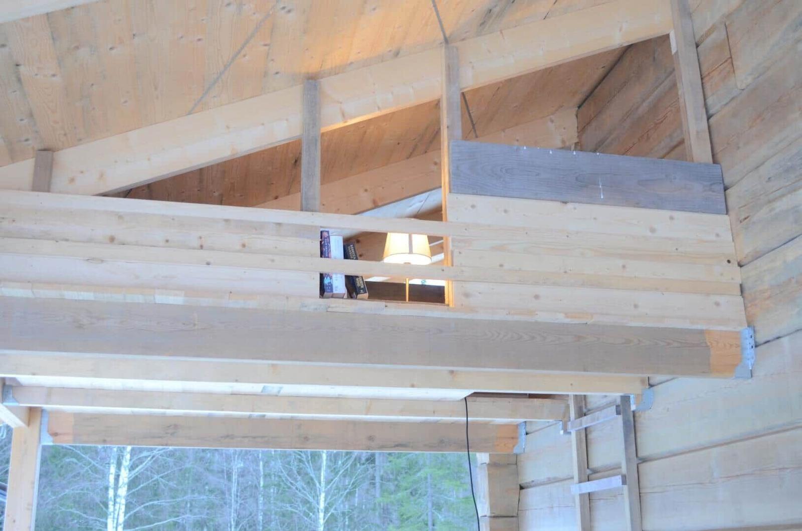 Wooden structure with bookshelf and lamp on upper level