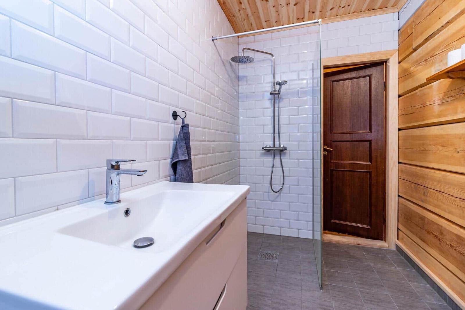 Bathroom with shower, sink, and wooden wall