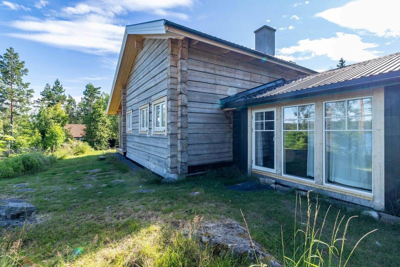 Wooden house with windows and roof under blue sky