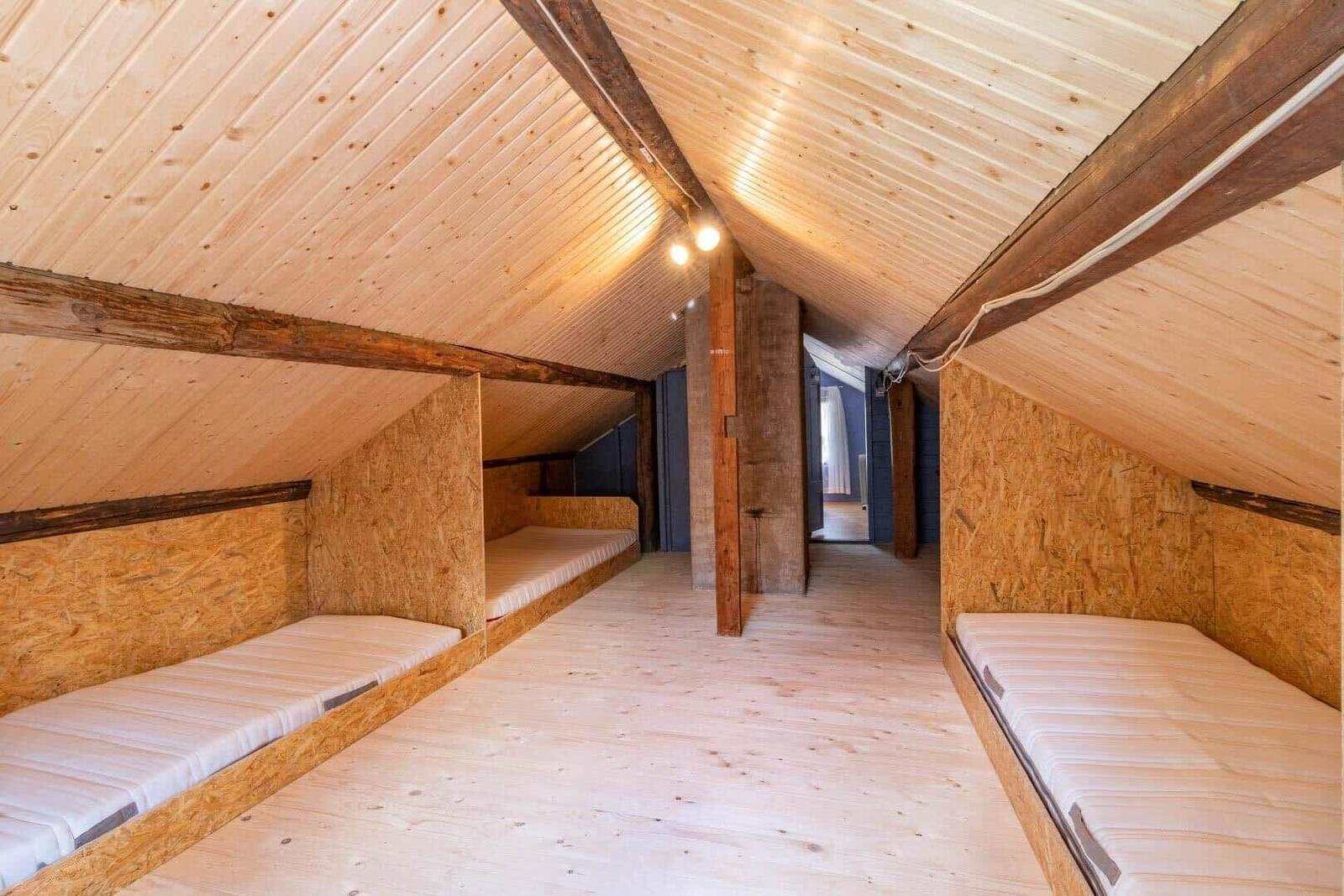 Attic room with wooden beds and wooden ceiling.