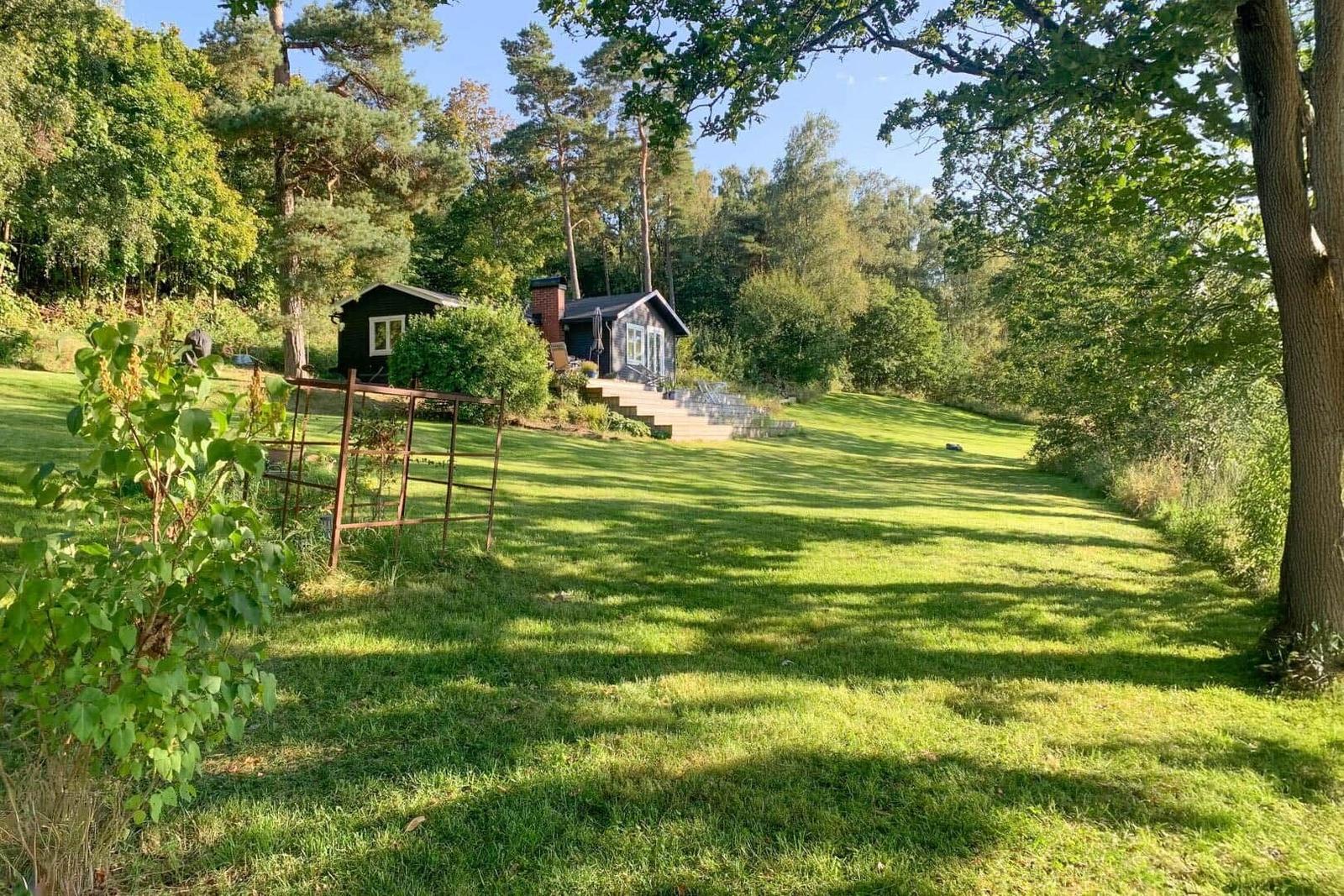 Haus mit großem Garten und Wald im Hintergrund.