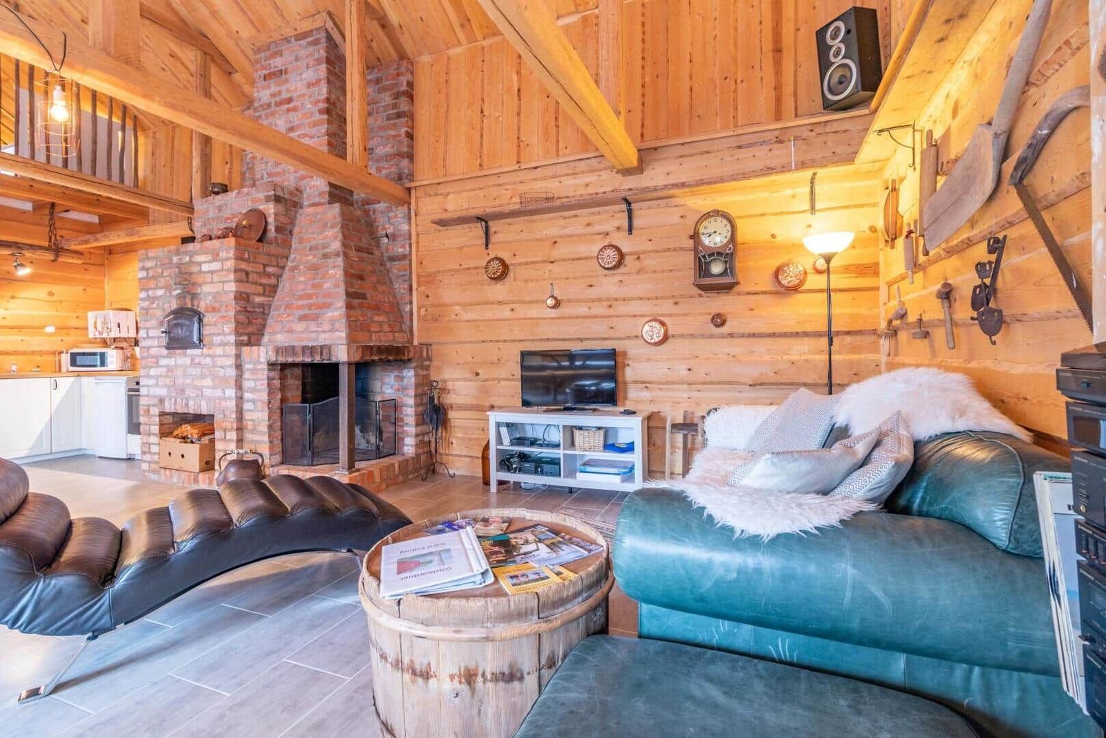 Wohnzimmer mit Kamin, Sofa und Holzwand