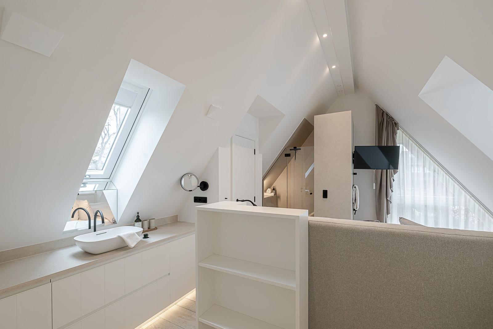 Dachgeschossbad mit Dusche, Waschbecken und Fenster