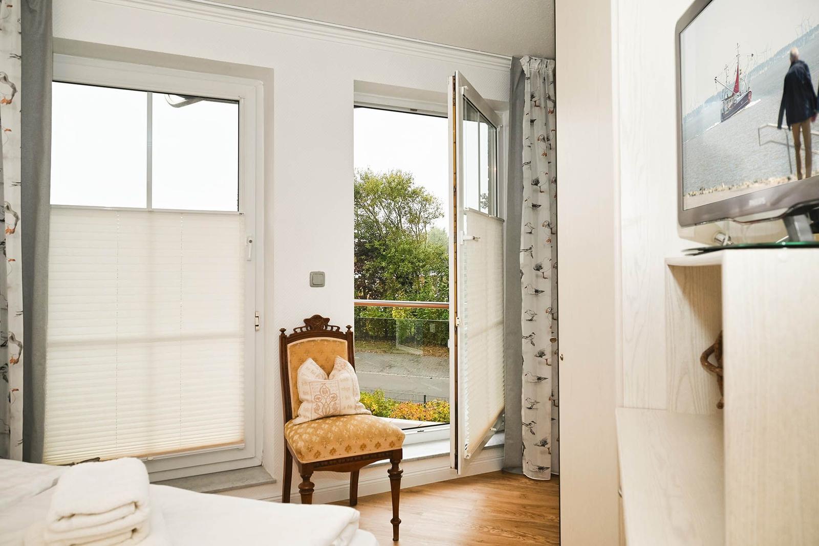 Ein Zimmer mit Blick auf Balkon, Stuhl und Fernseher