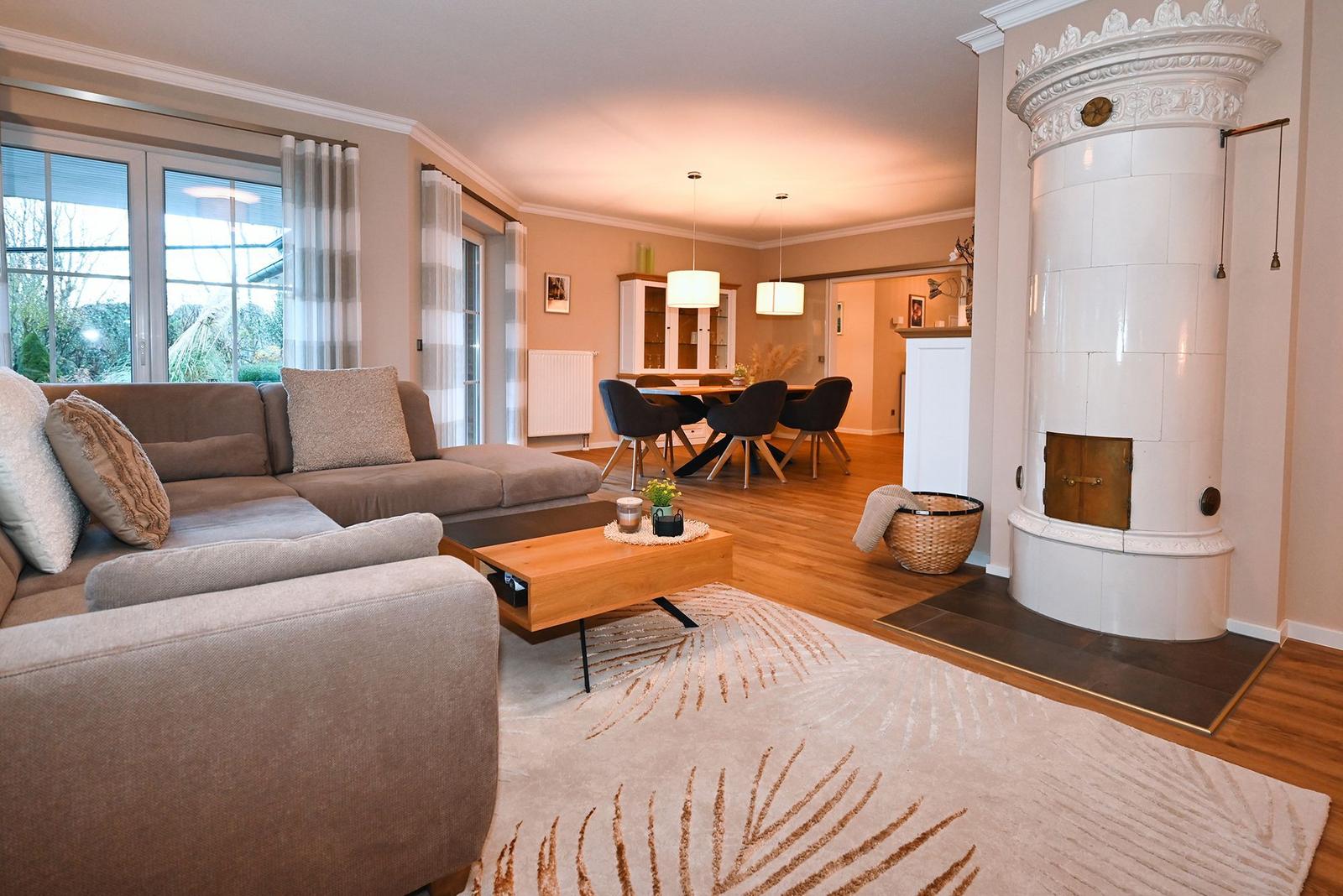 Wohn- und Essbereich mit Sofa, Kamin und Holzboden.